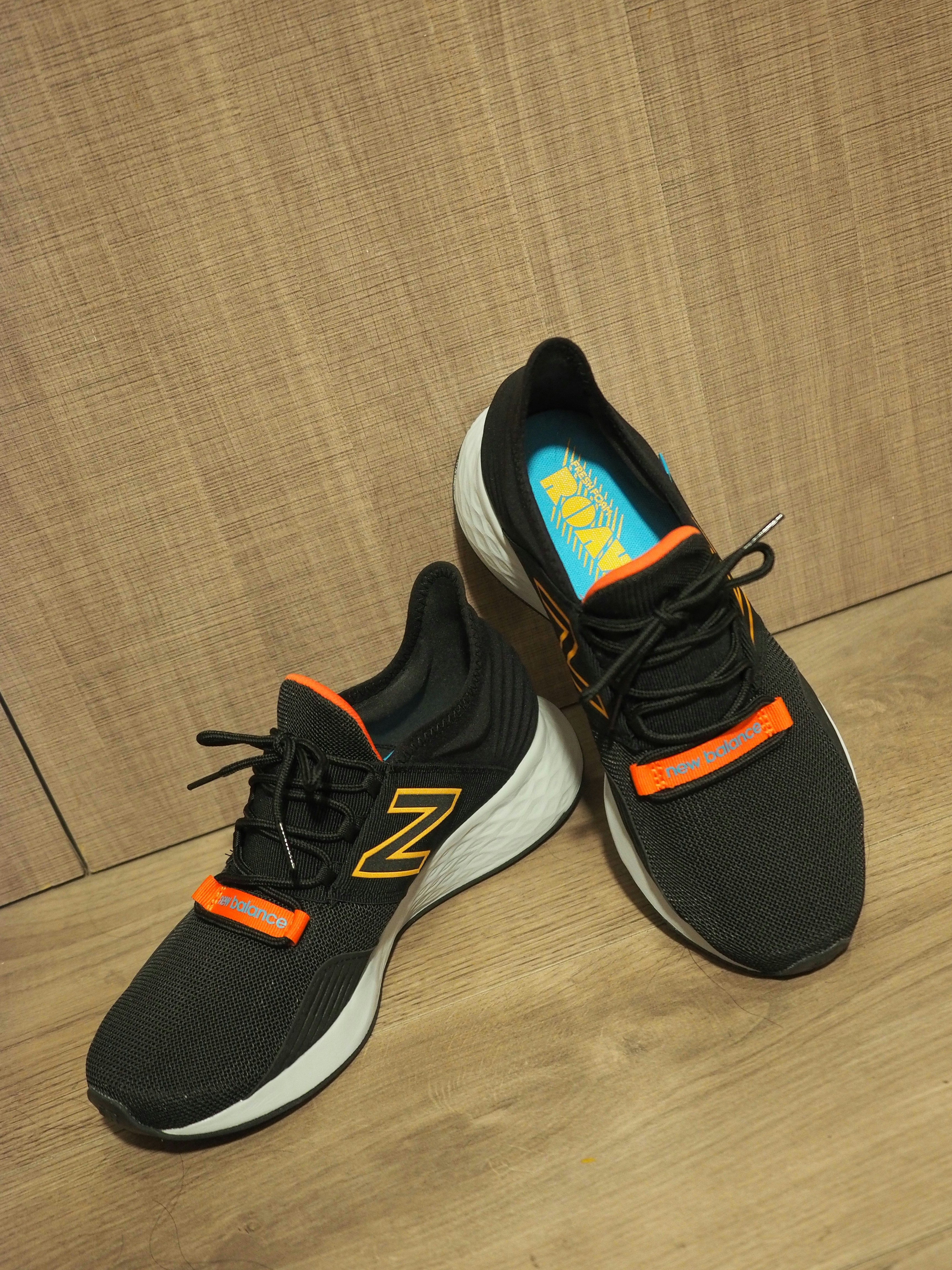 A pair of new balance shoes on a wooden floor
