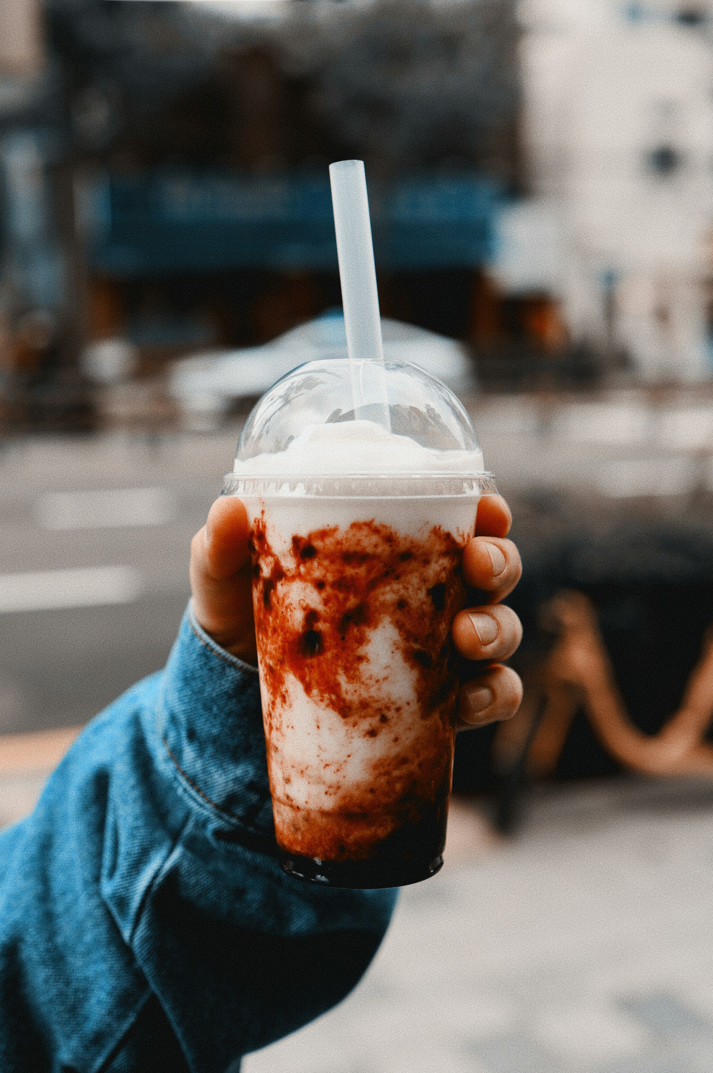 A person holding a cup with a straw in it