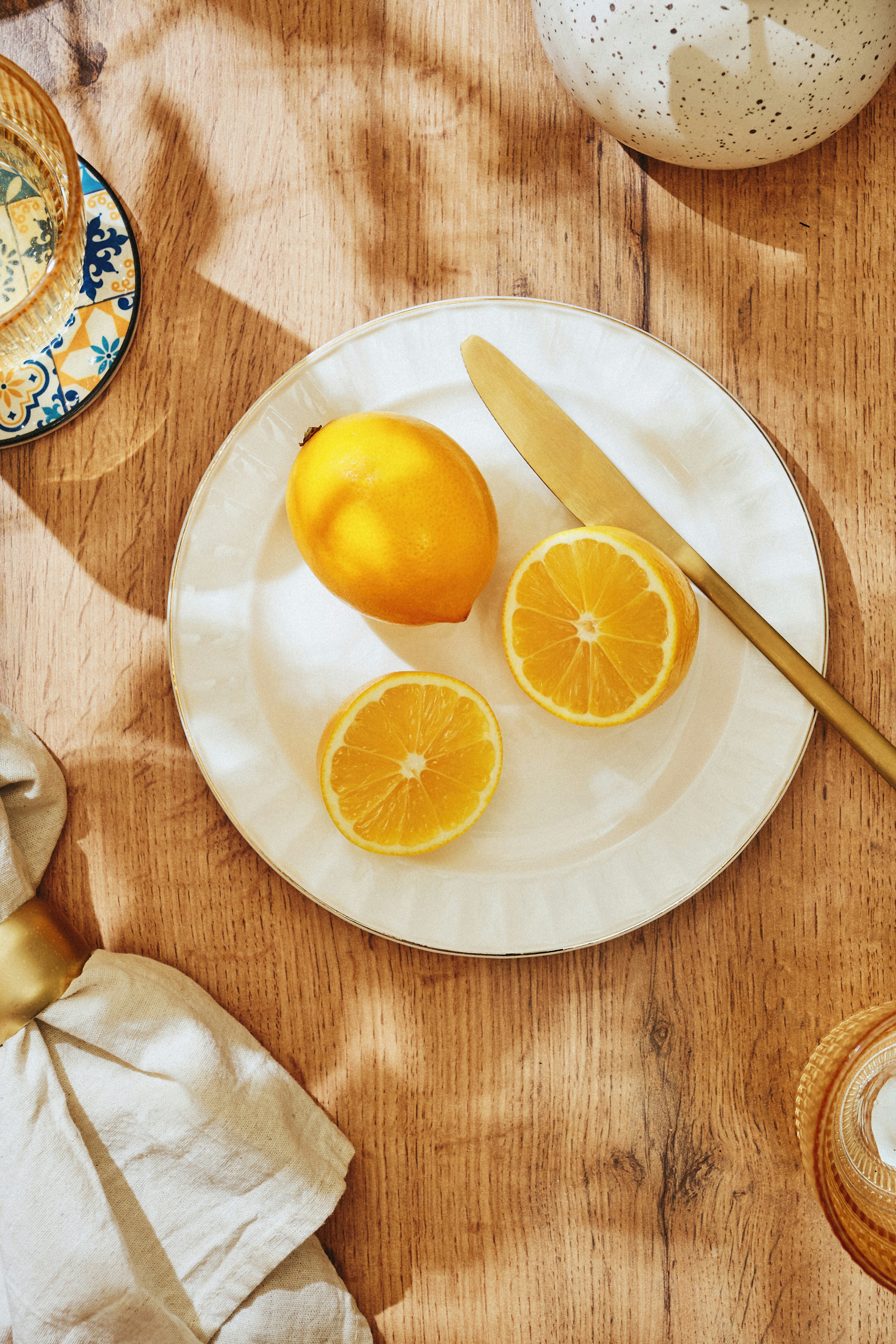 A wooden table topped with a plate of oranges