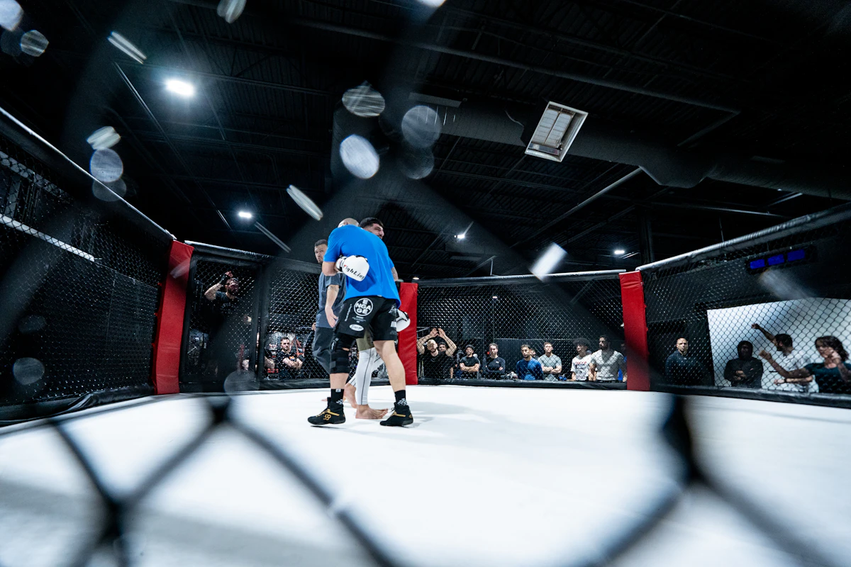 Two fighters in a boxing ring under the lights