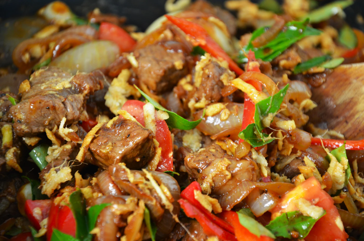 Glossy ginger beef stir-fry with peppers, onions, scallions, and sesame seeds