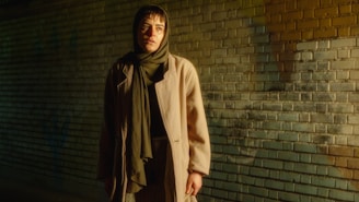 A woman standing in front of a brick wall