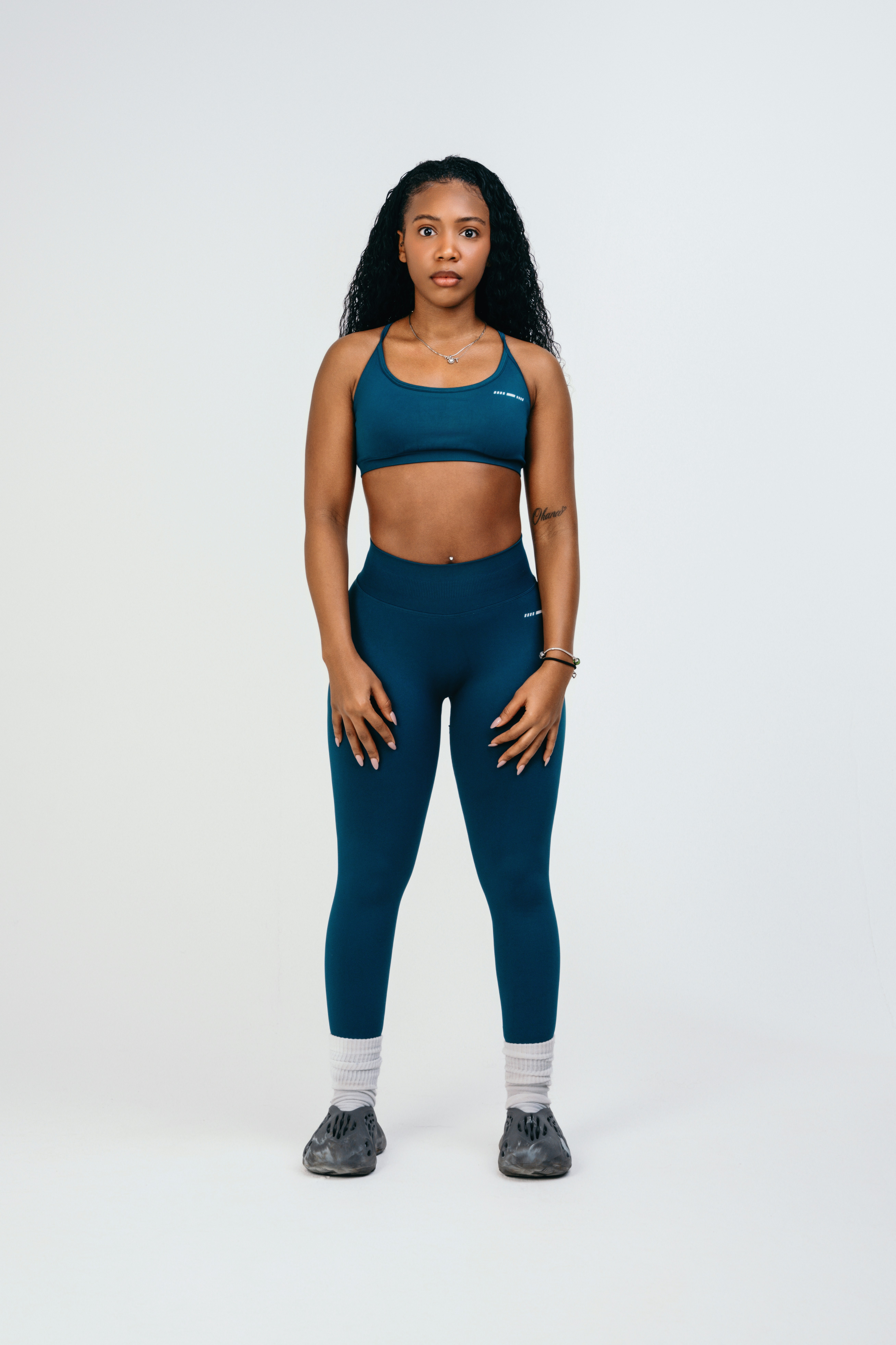 A woman in a blue sports bra top and leggings