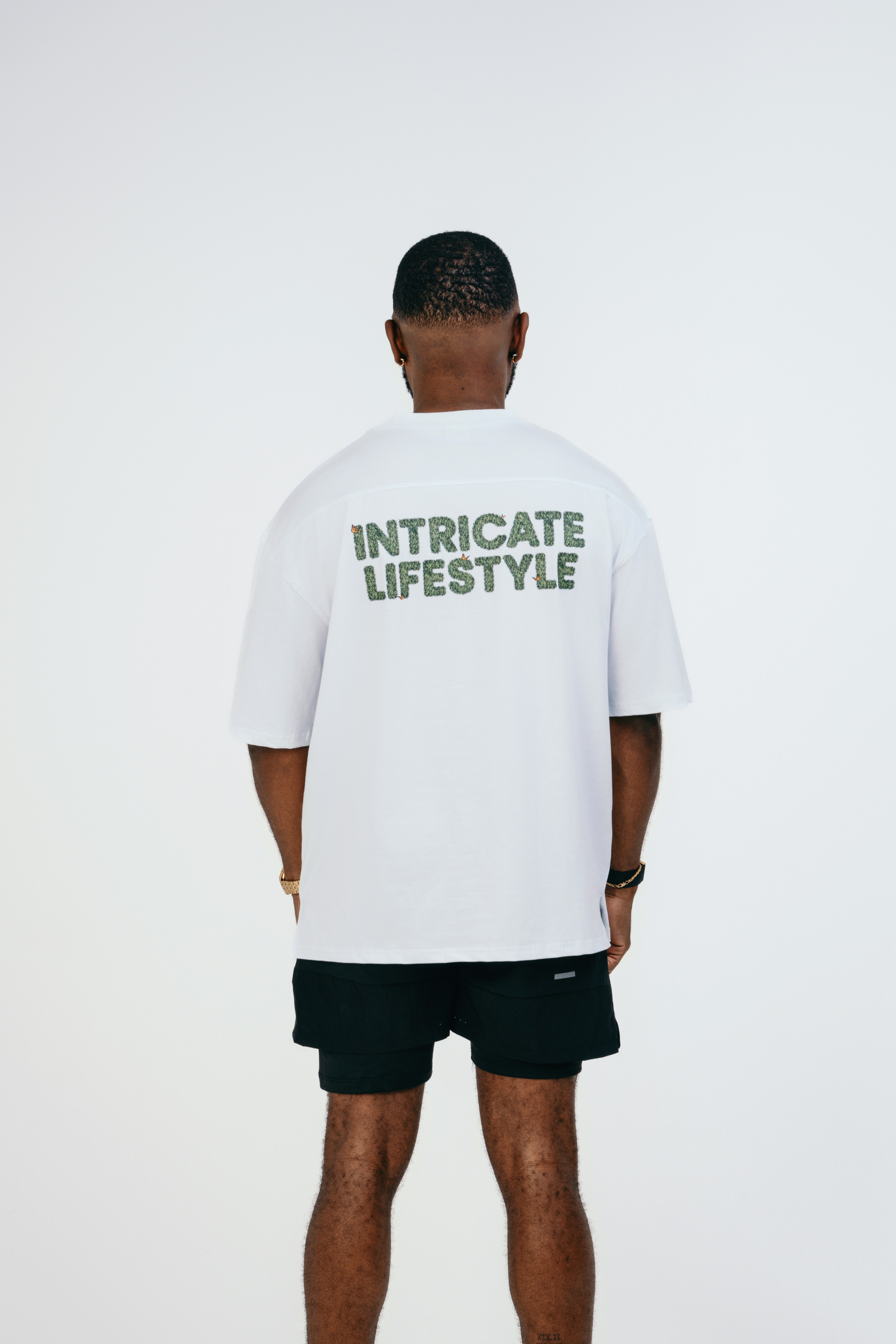 A man wearing a white t - shirt with green lettering