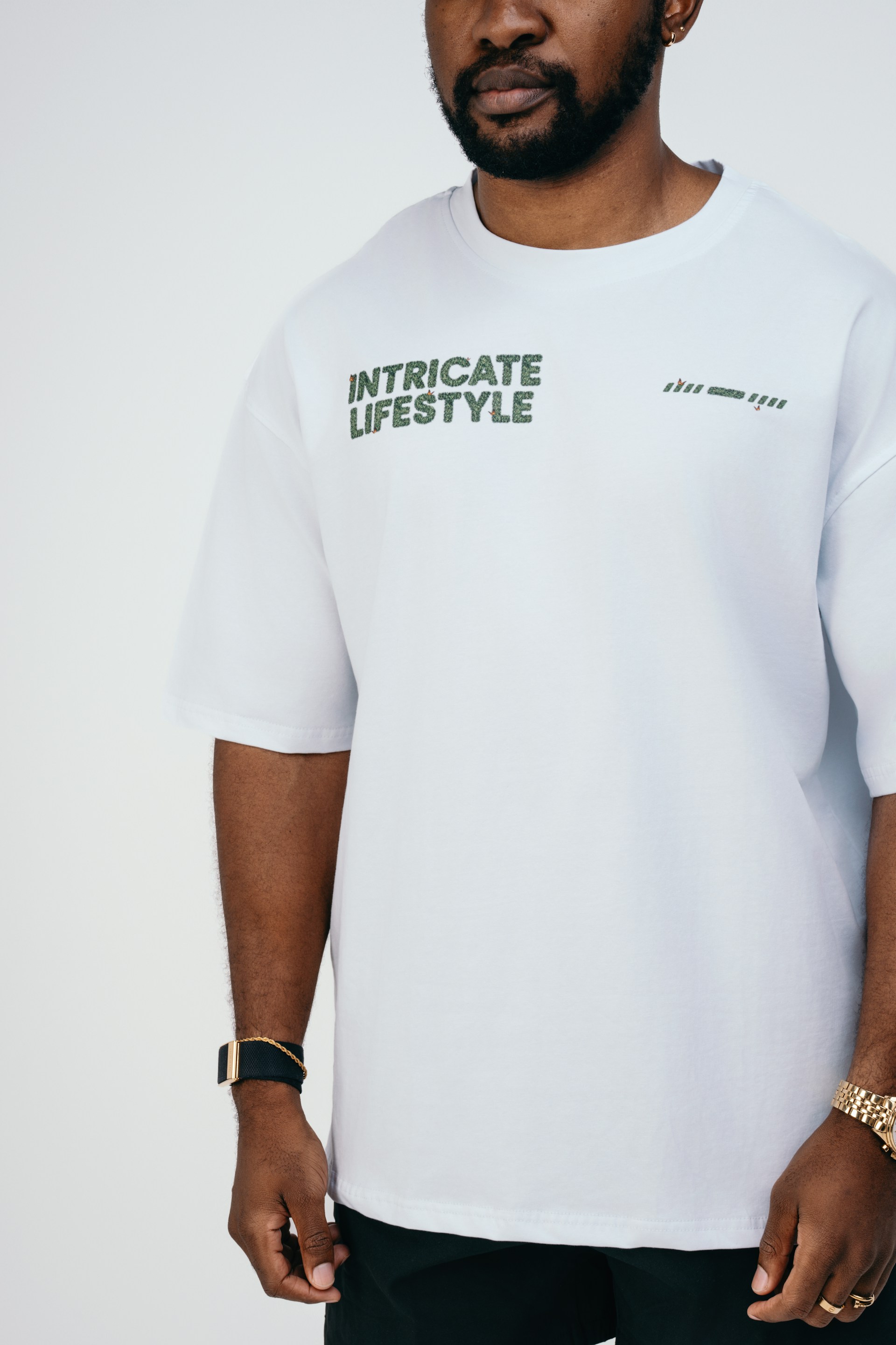 A man wearing a white shirt with a green print on it