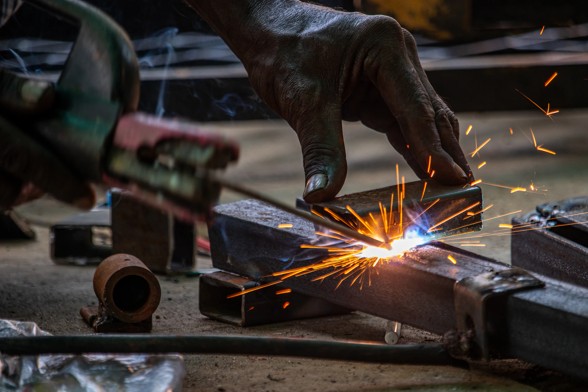 A person using a grinder on a piece of metal