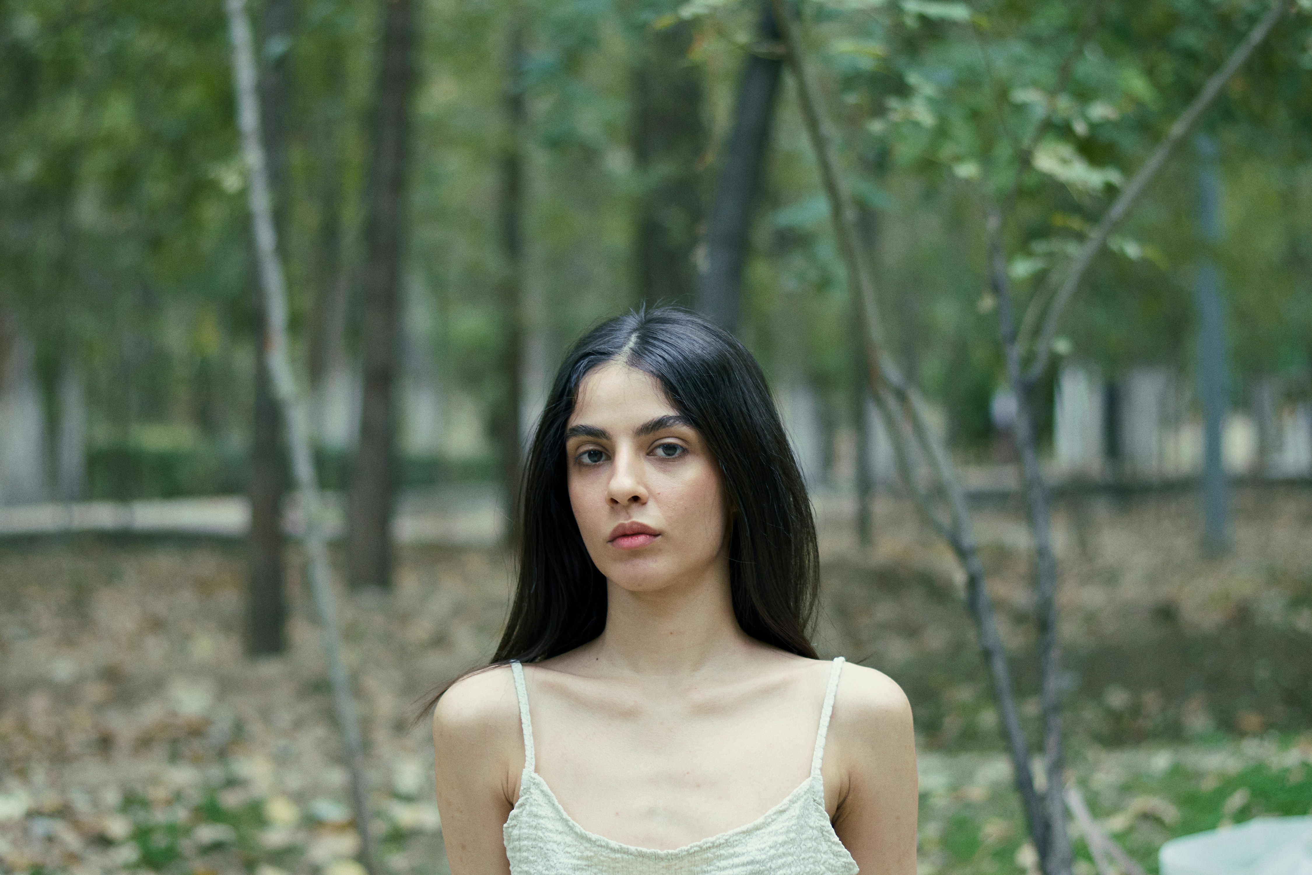 A woman standing in the woods with her hands in her pockets
