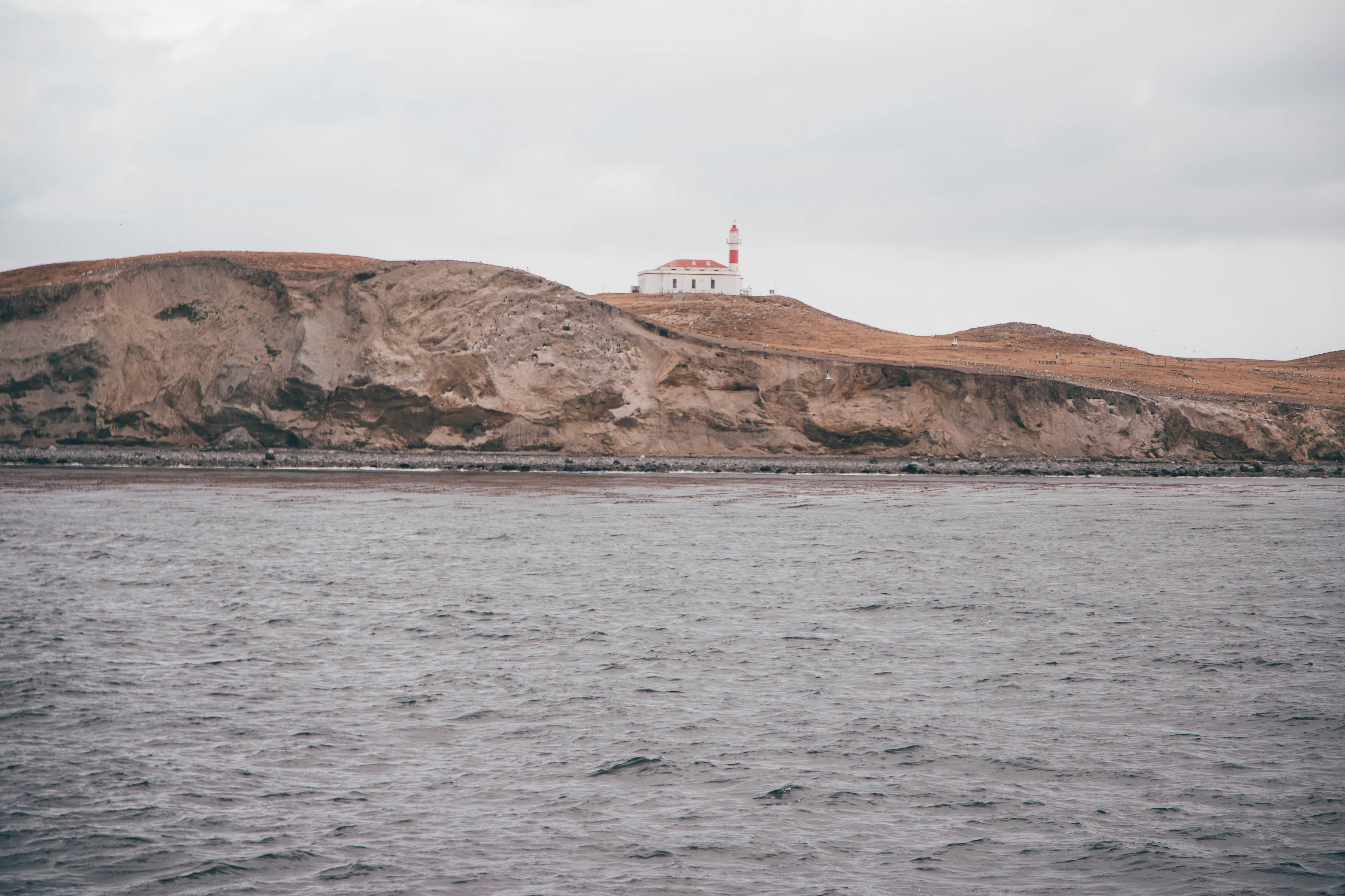A body of water with a hill in the background