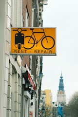 A yellow sign hanging from the side of a building