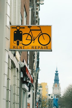 A yellow sign hanging from the side of a building