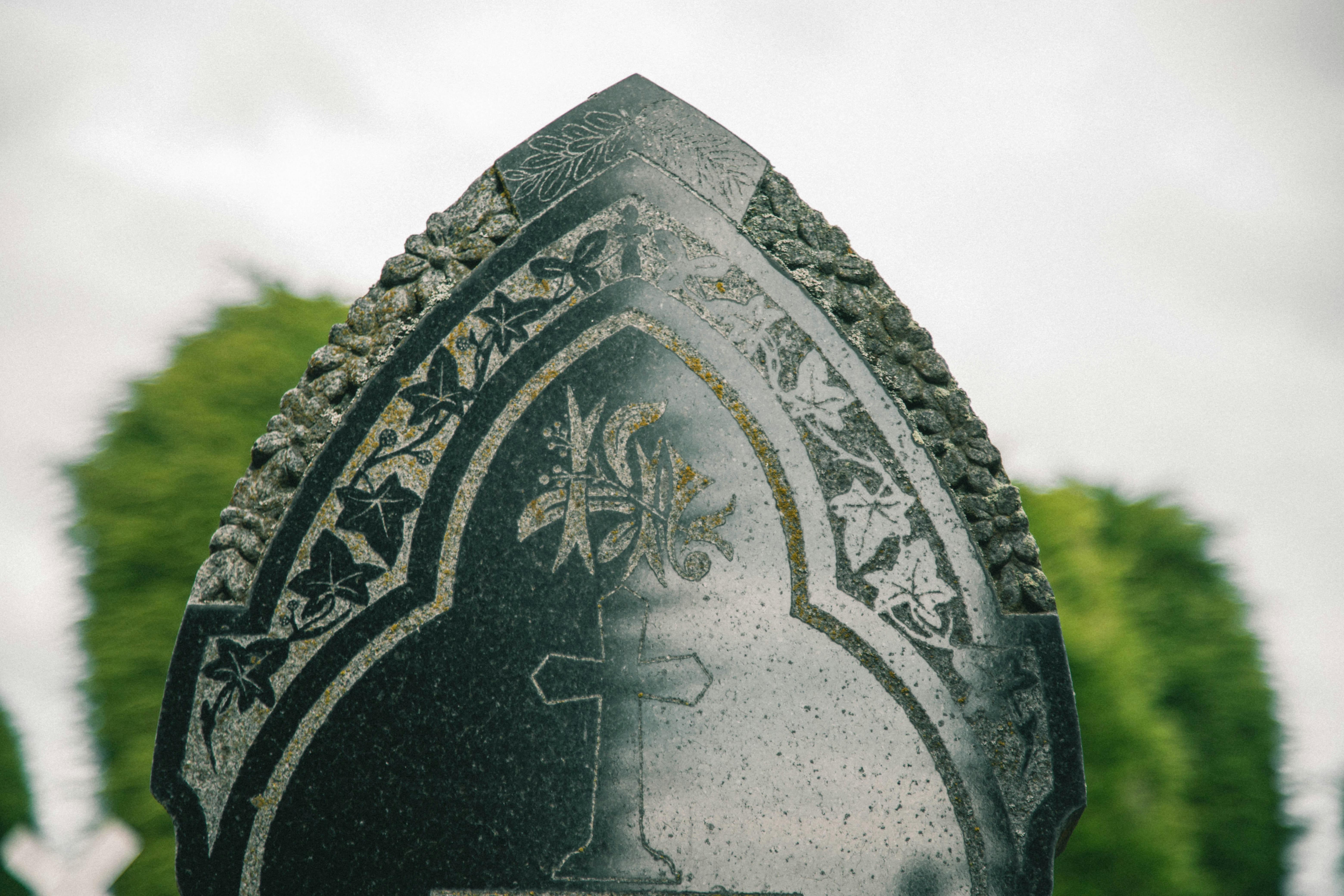 A close up of a grave marker with trees in the background
