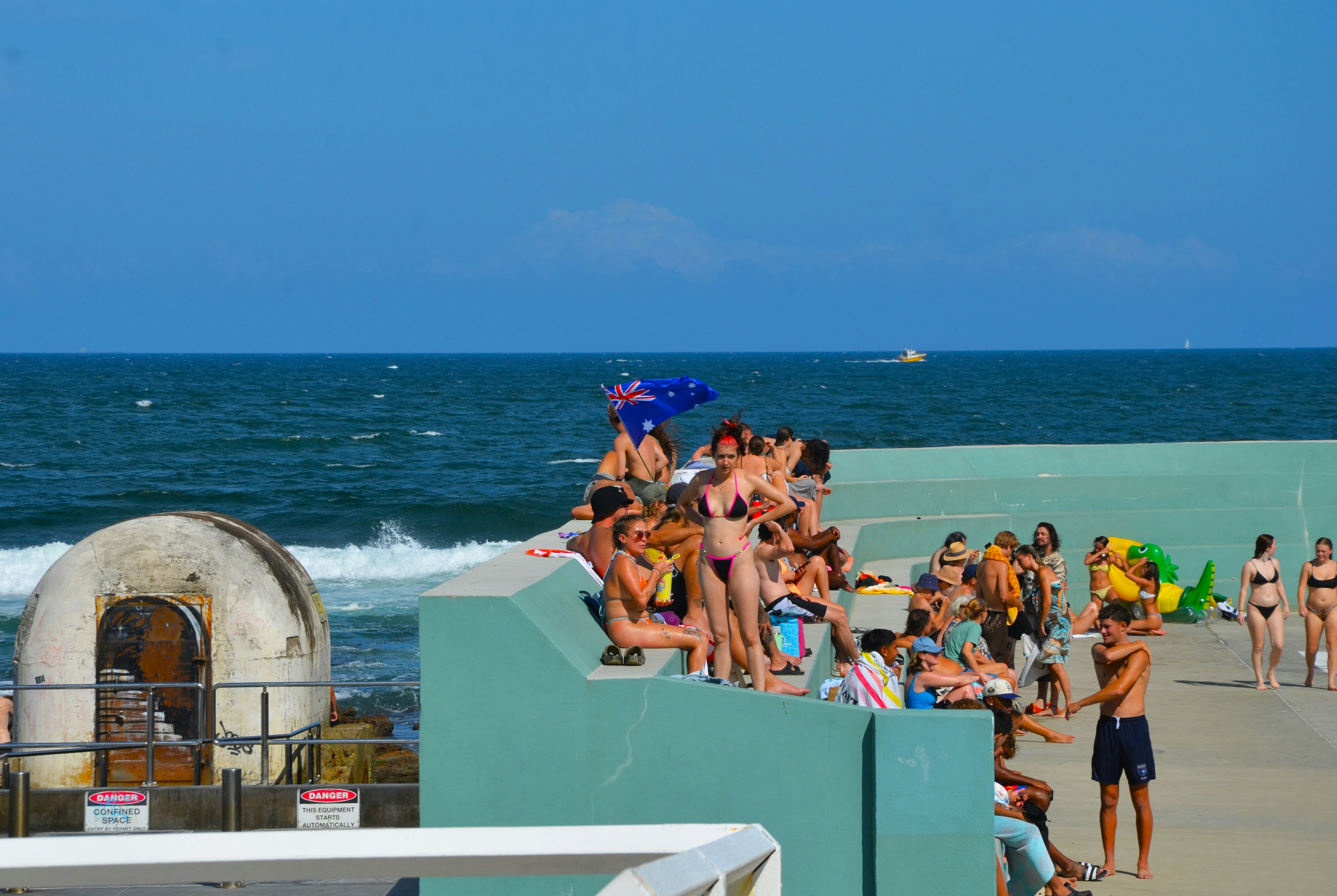 A group of people standing on a beach next to the ocean