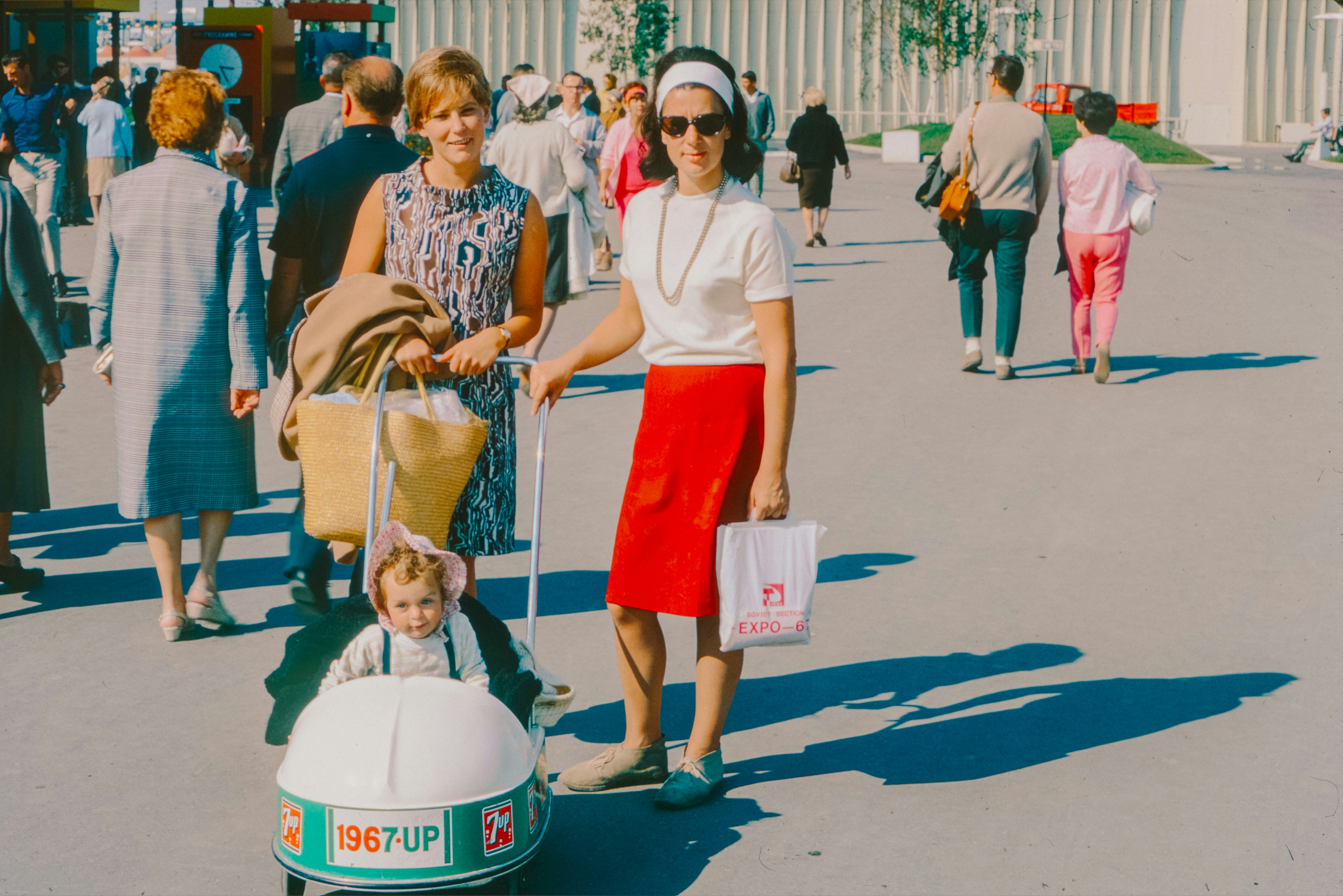 A woman pushing a cart with a child in it