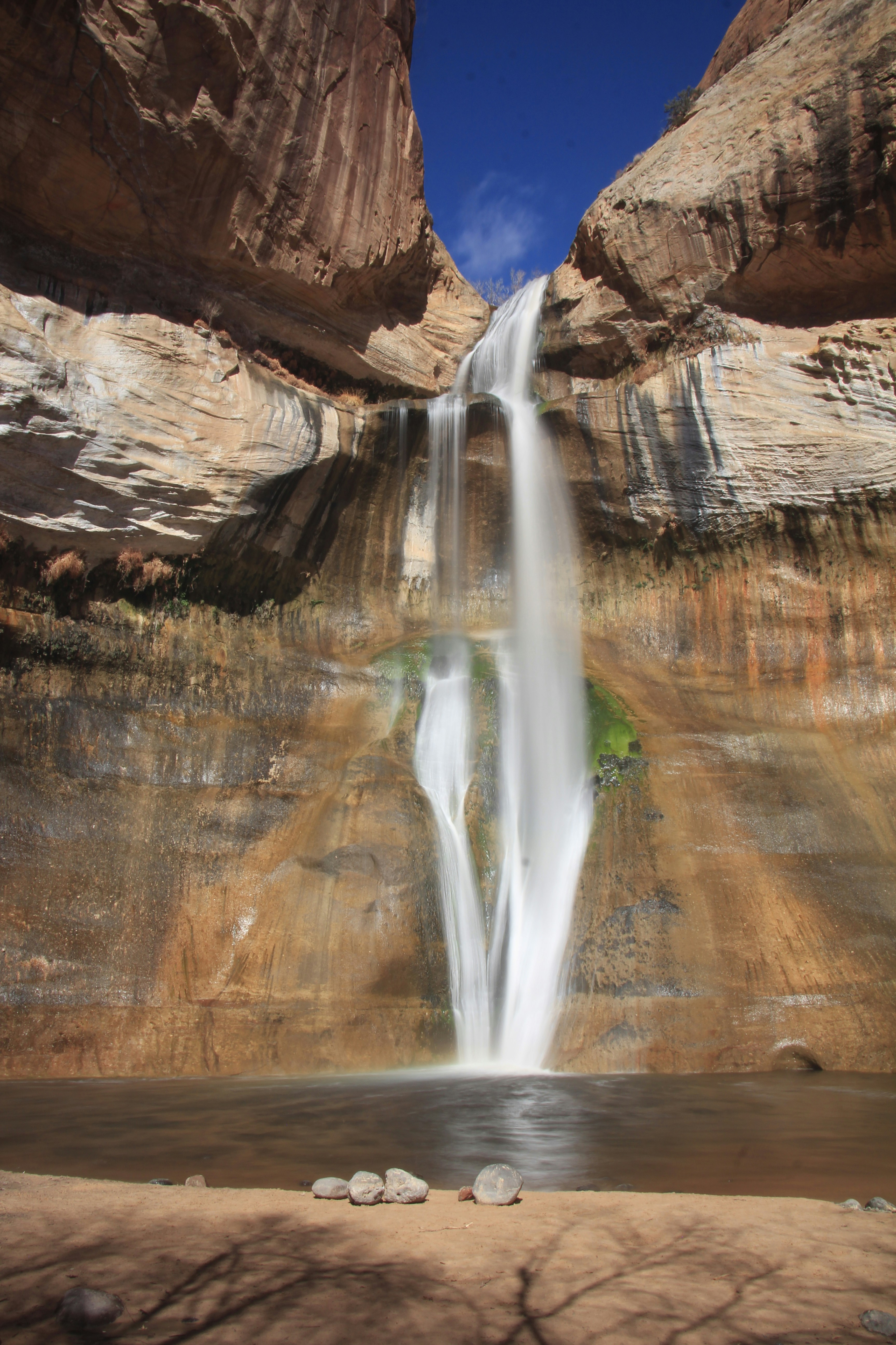 A waterfall is seen from the bottom of a cliff