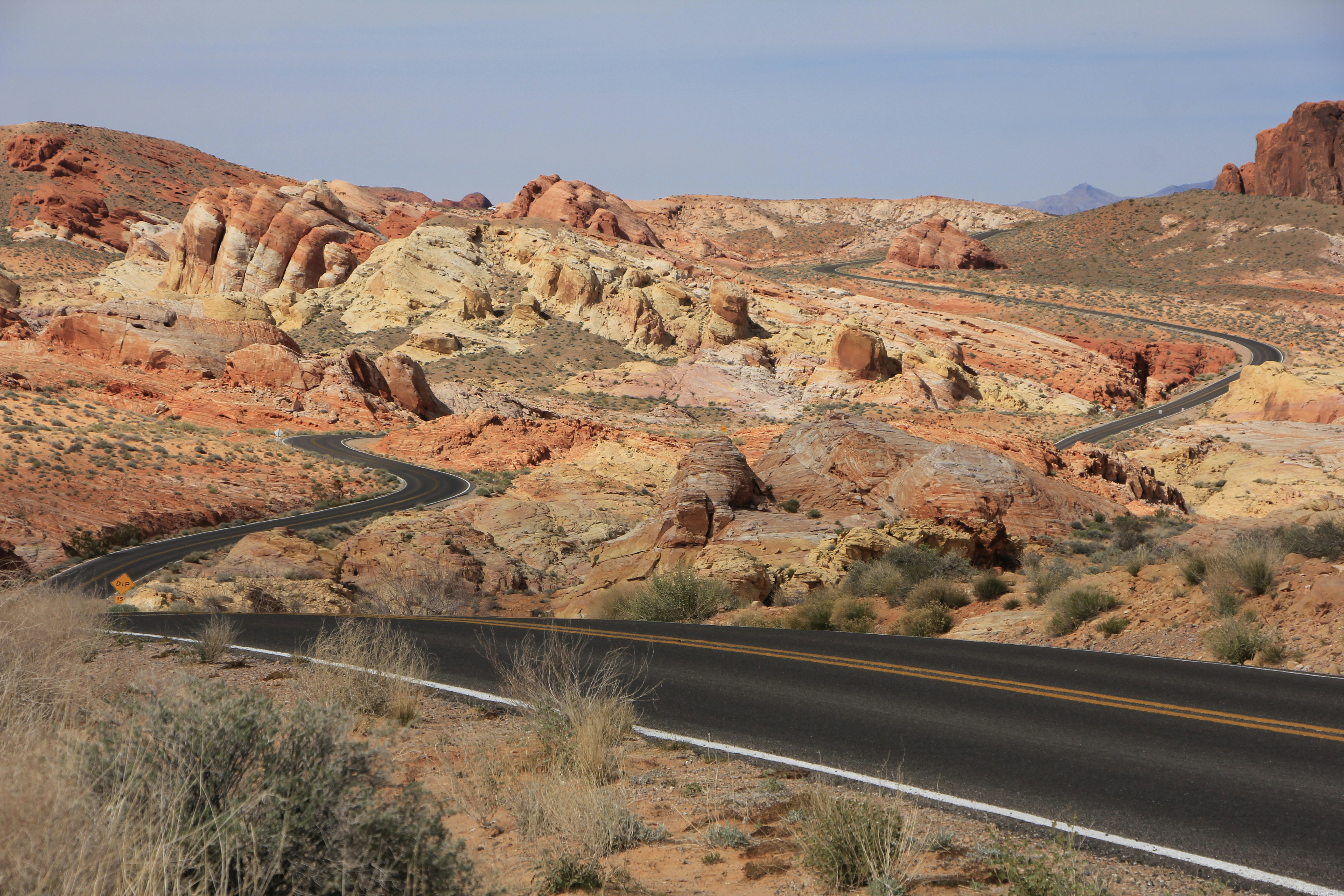 A road in the middle of a desert with mountains in the background