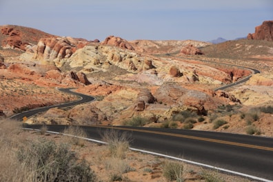 A road in the middle of a desert with mountains in the background