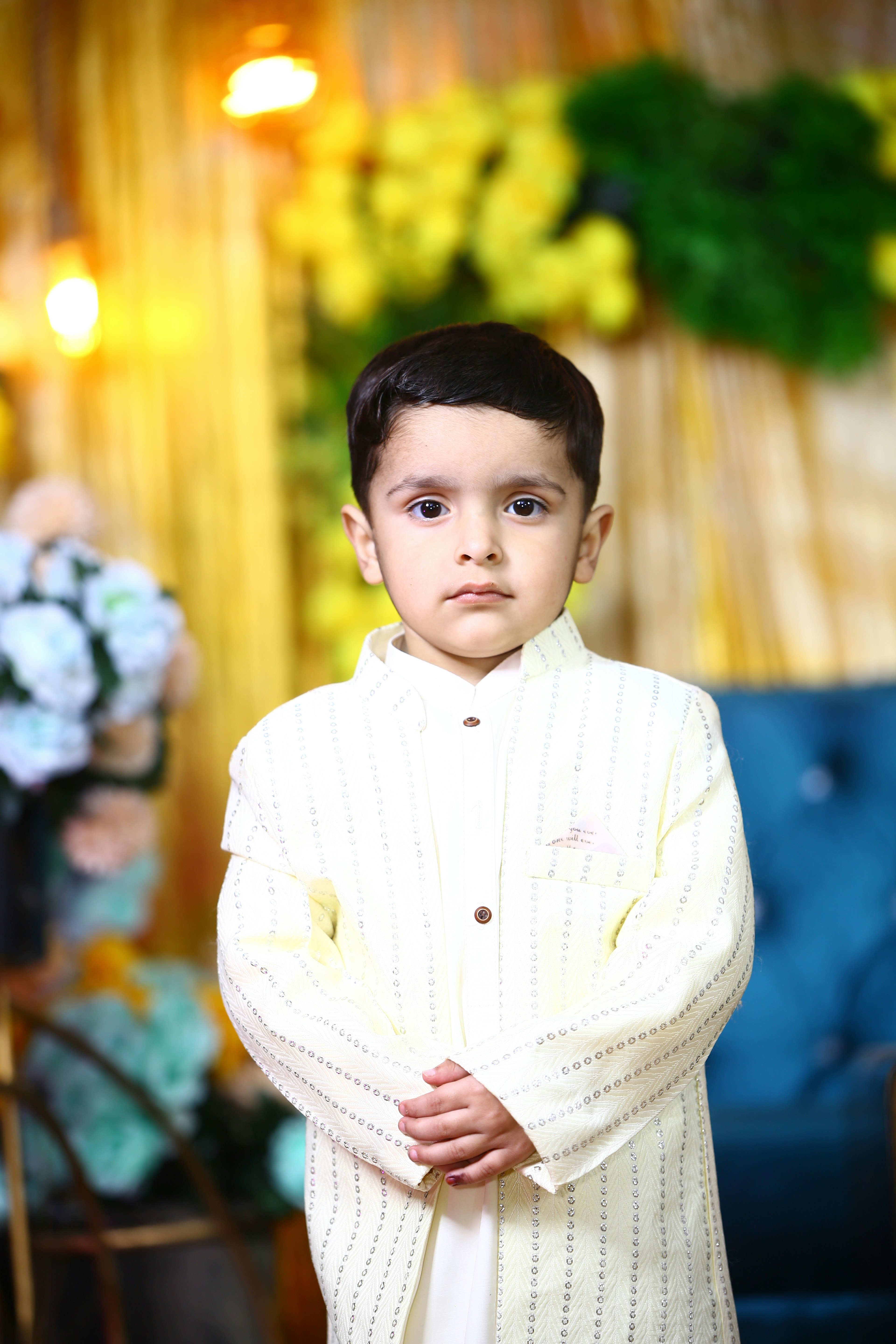 A young boy standing in front of a blue couch