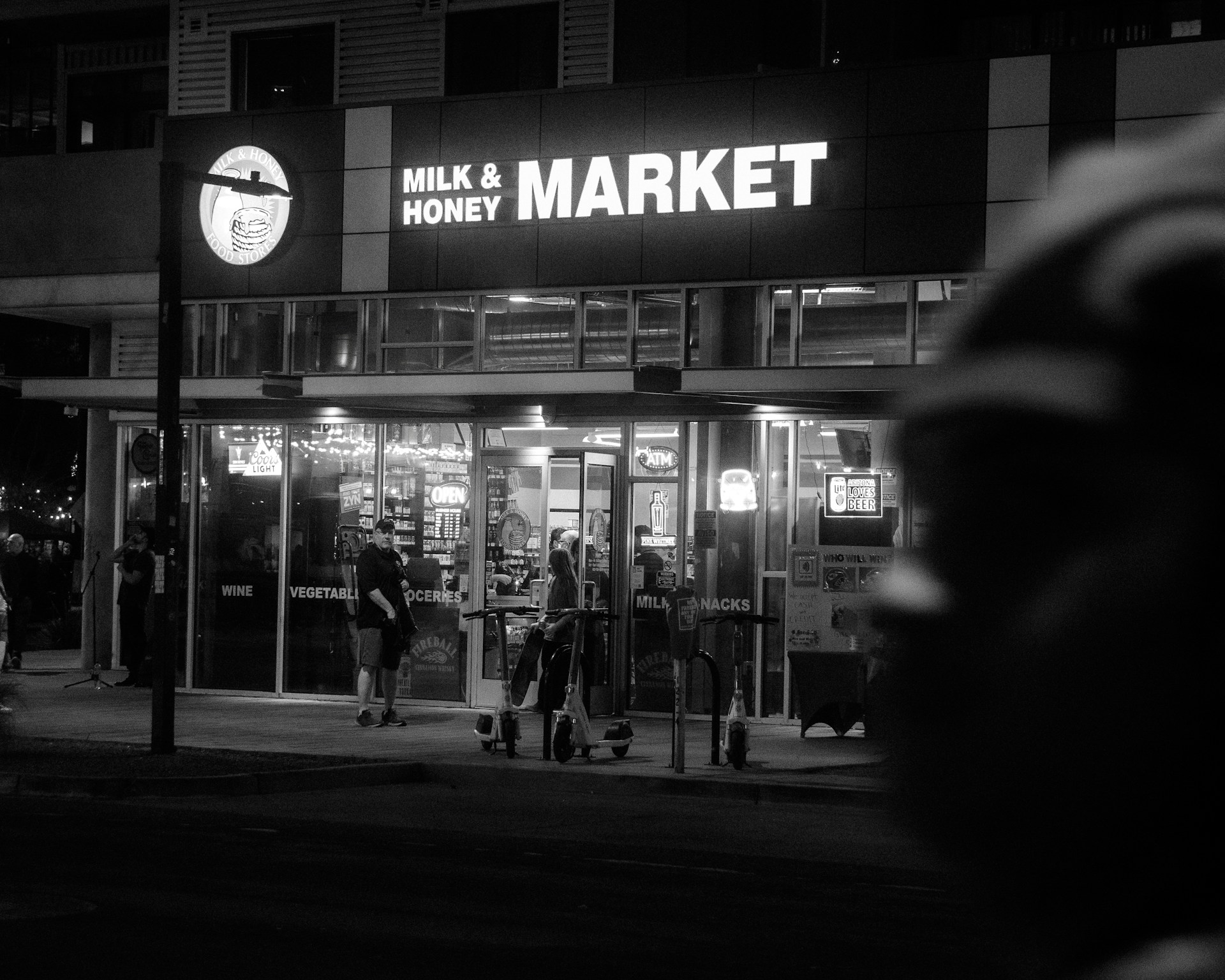 A black and white photo of a market at night