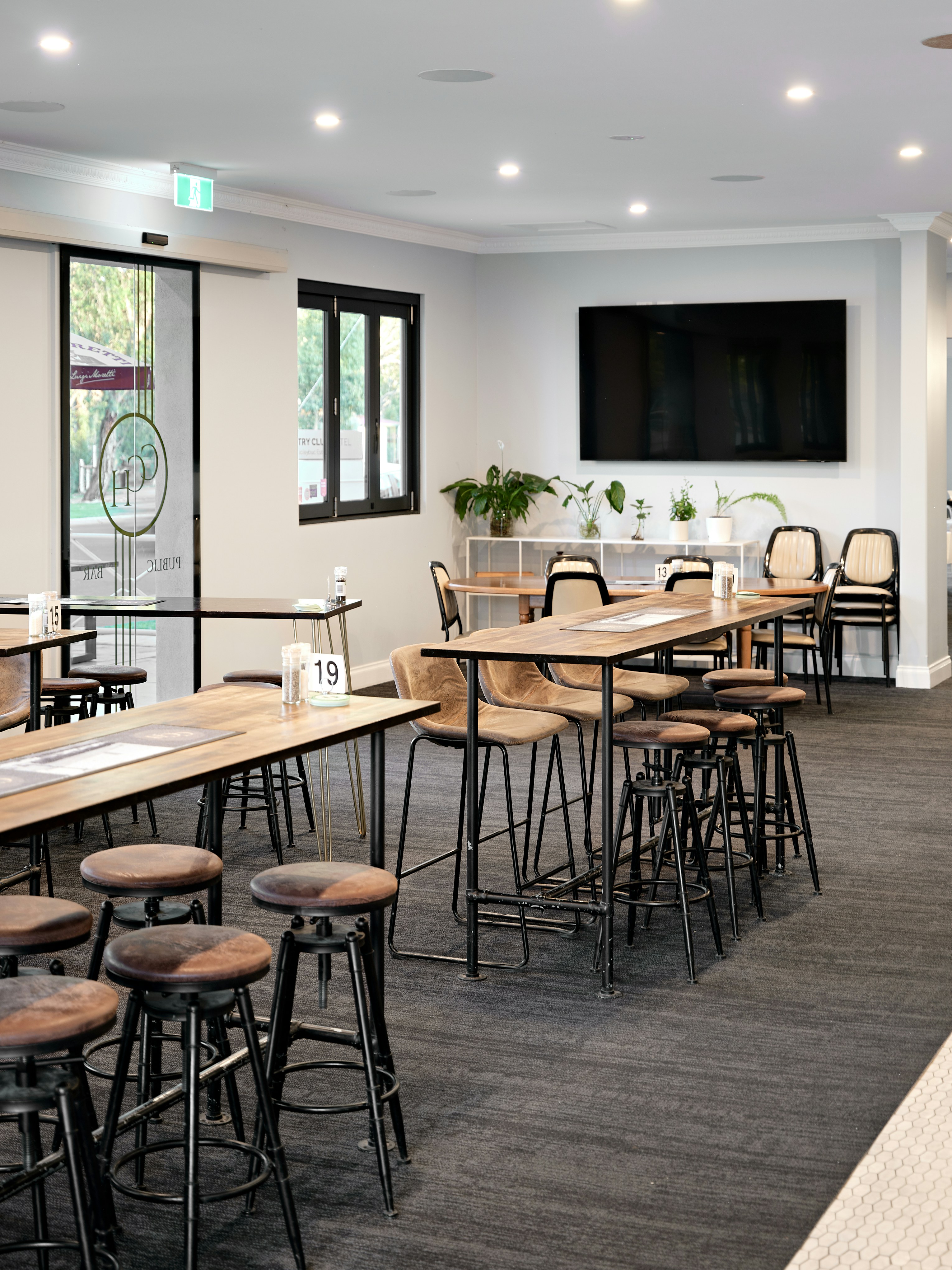 Una habitación con mesas y sillas y un televisor de pantalla plana