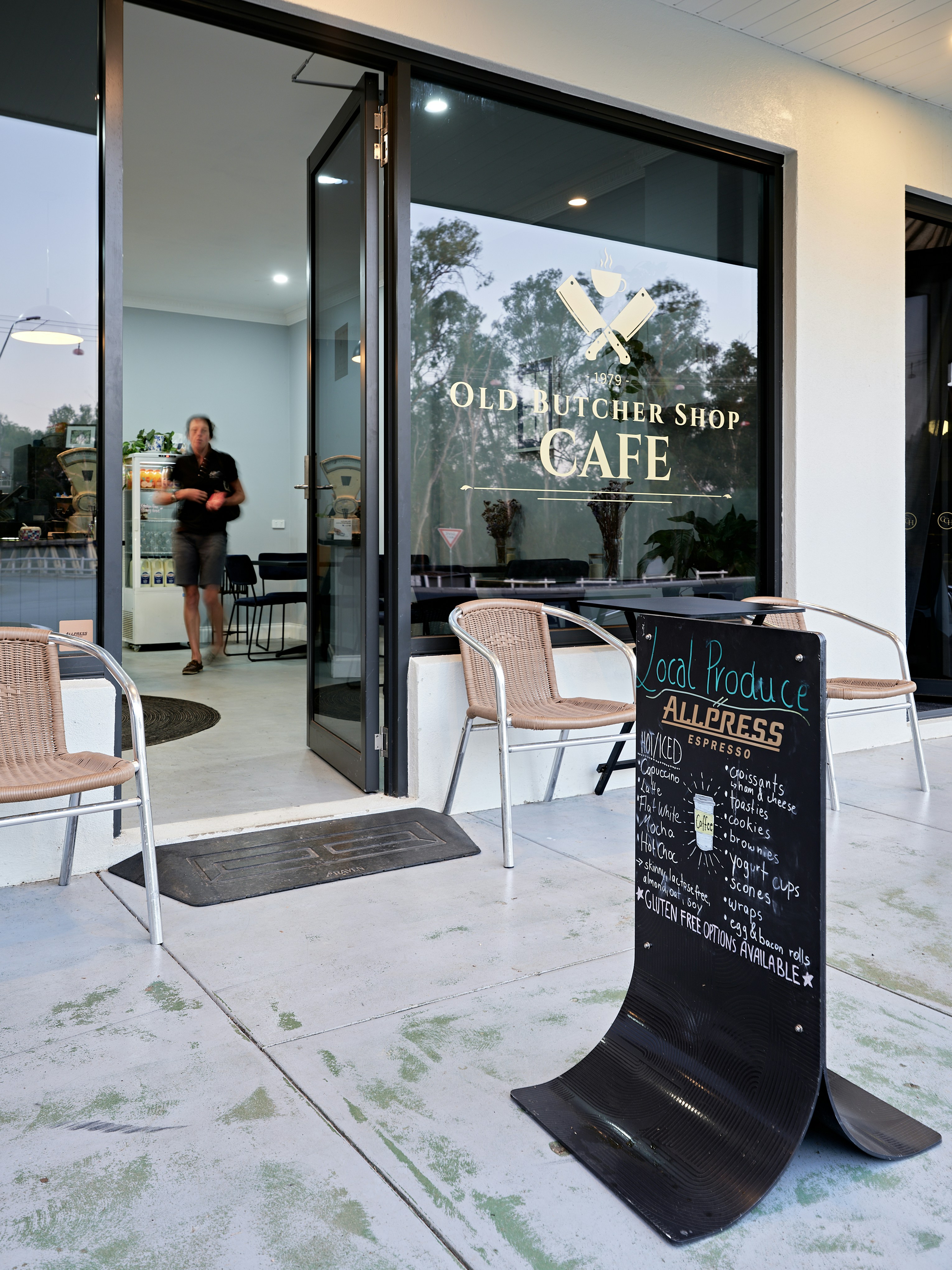 Una cafetería con sillas y un letrero frente a ella