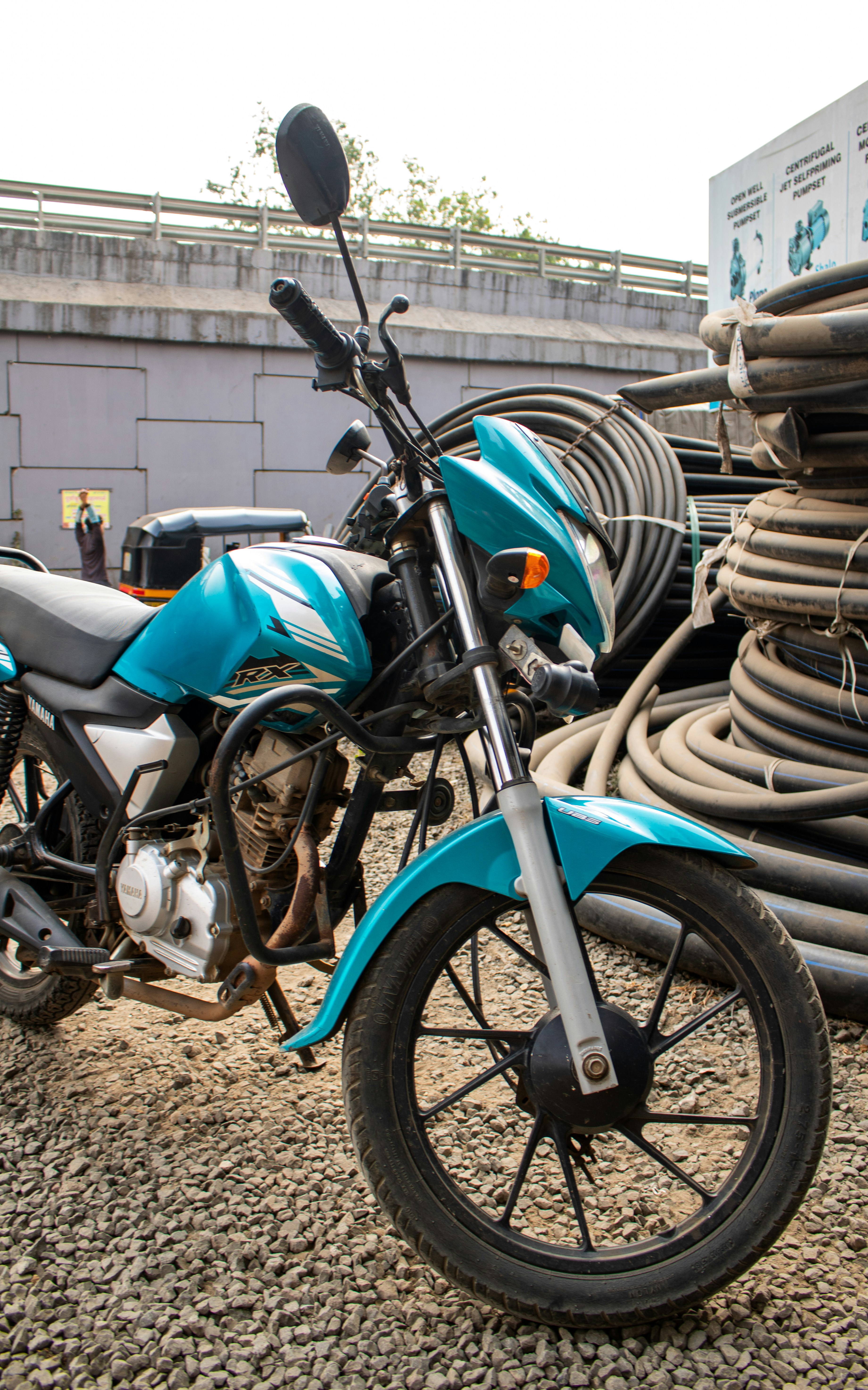 A blue motorcycle parked next to a pile of wires