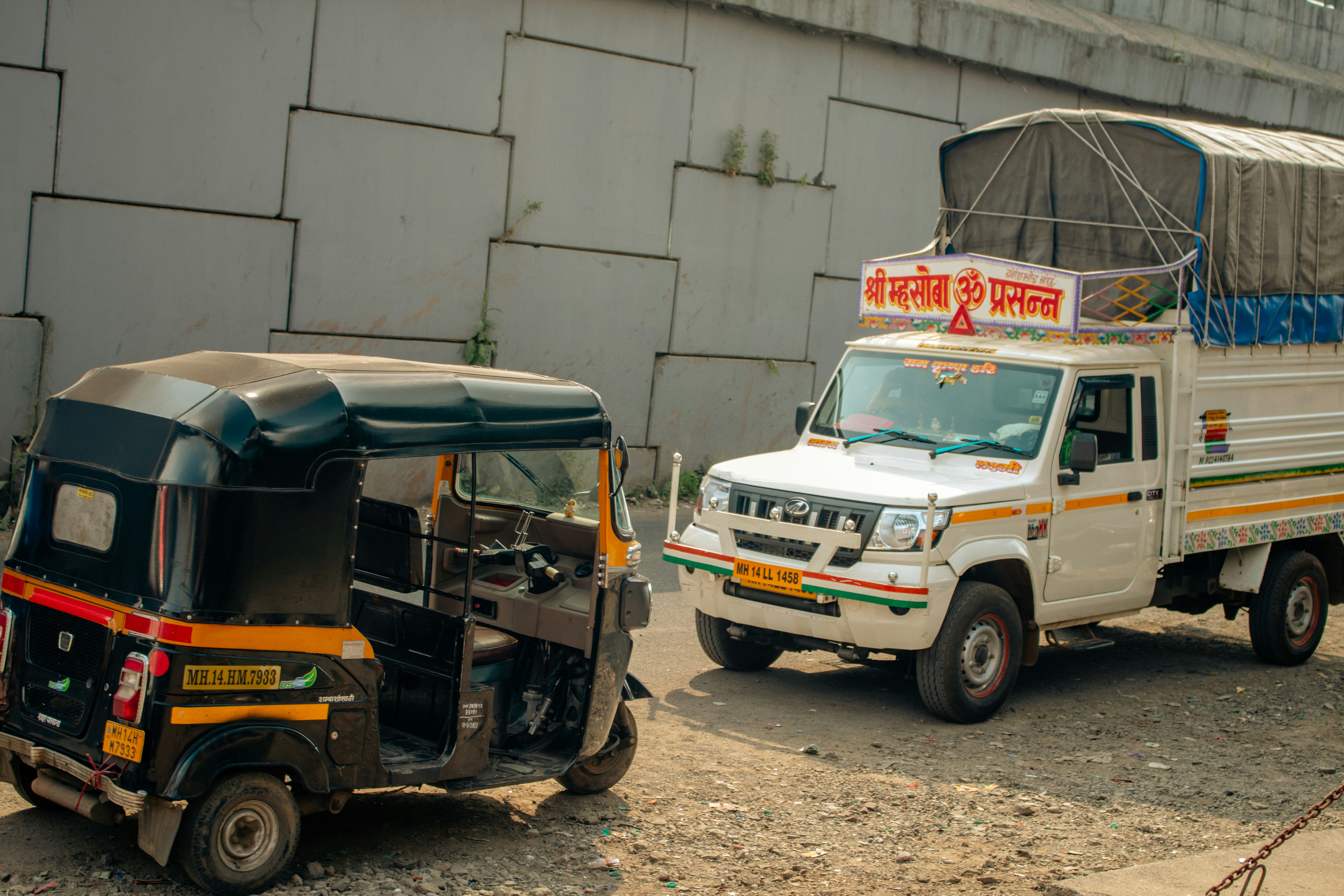 A white truck driving past a white van on a road