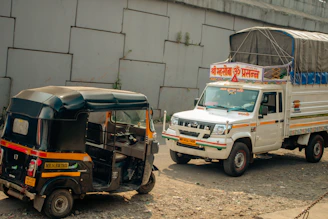 A white truck driving past a white van on a road