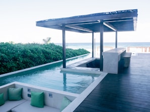A pool with a couch next to it near the ocean