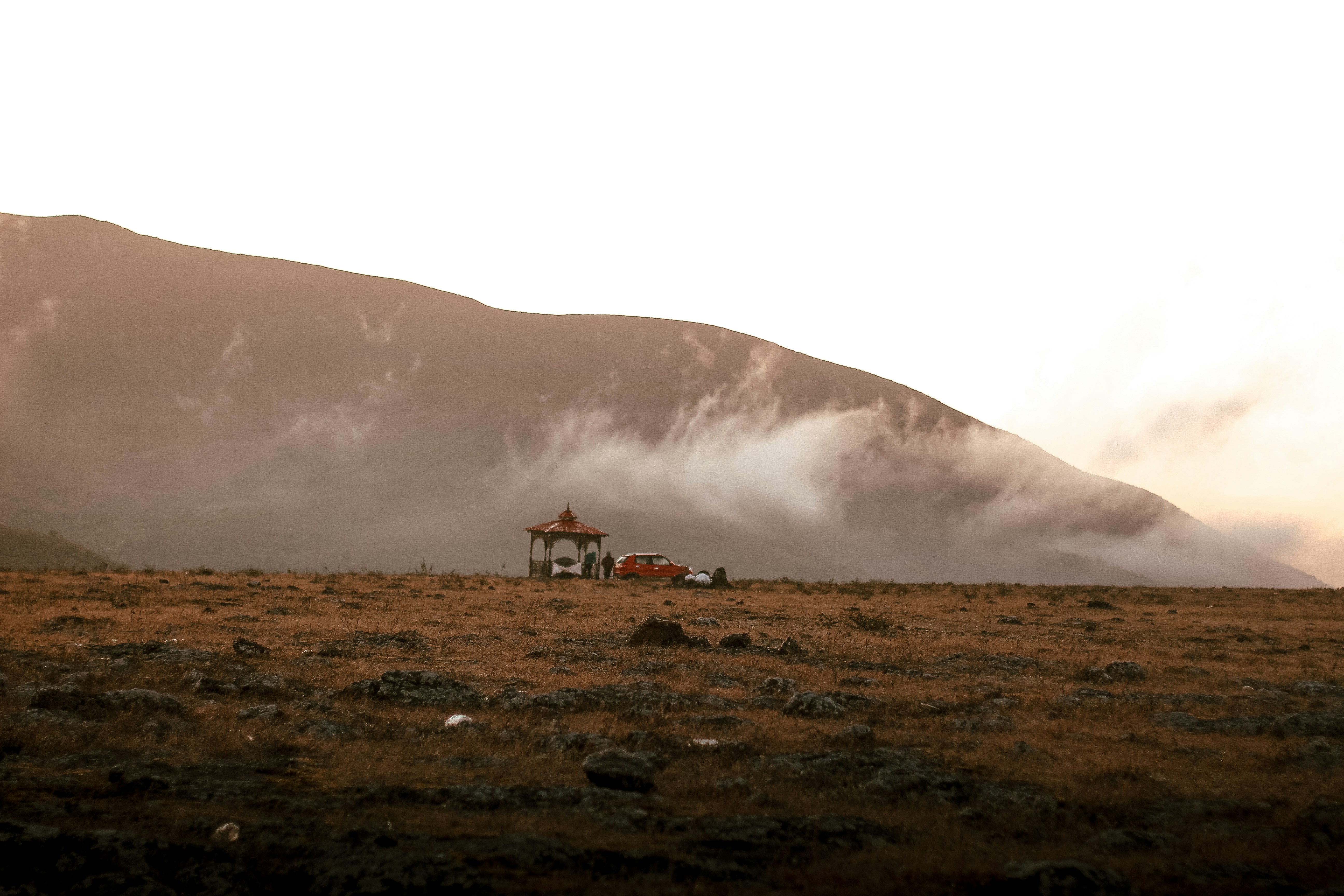 A lone house in a field with mountains in the background
