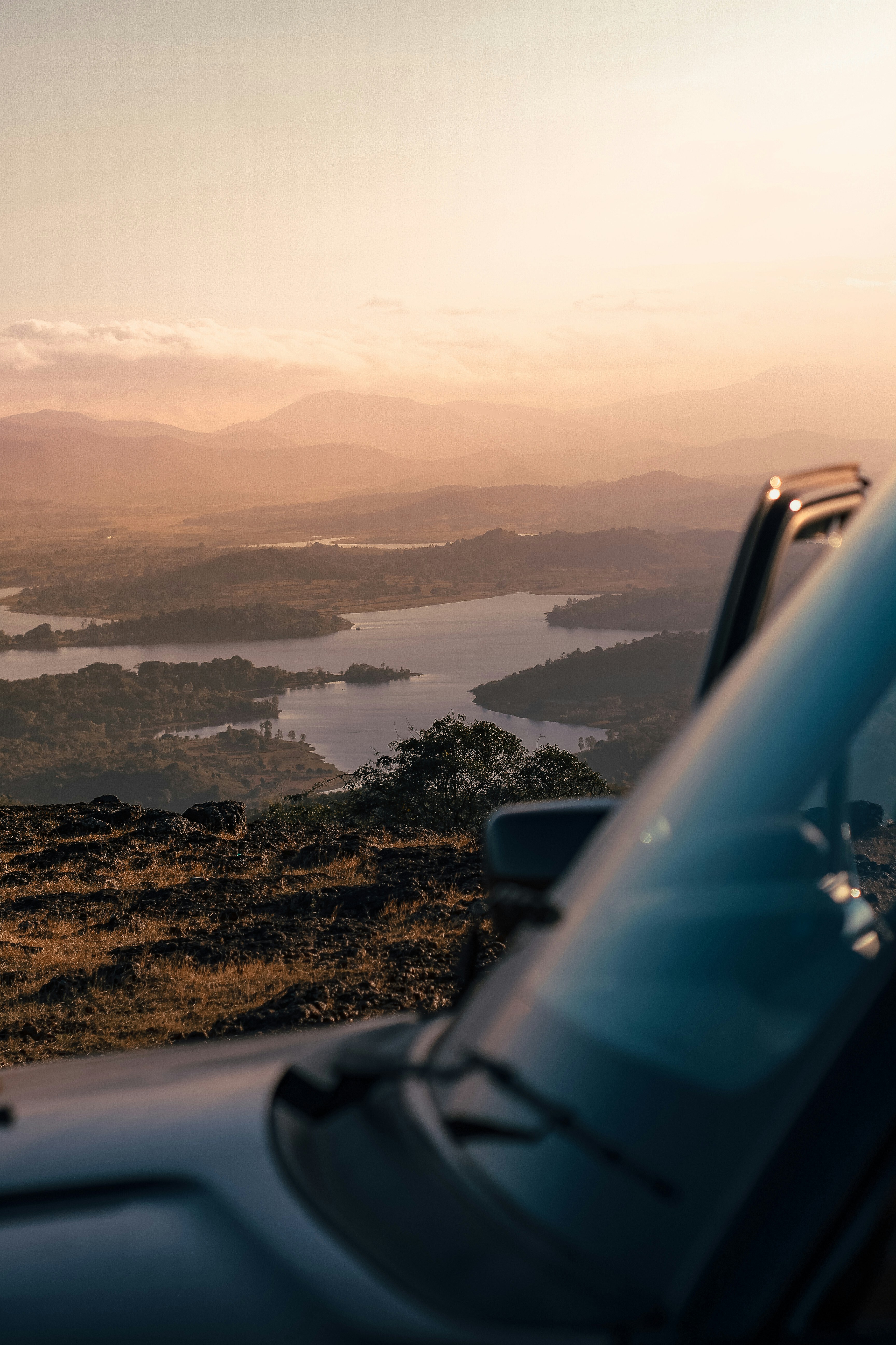 A car parked on top of a hill overlooking a lake