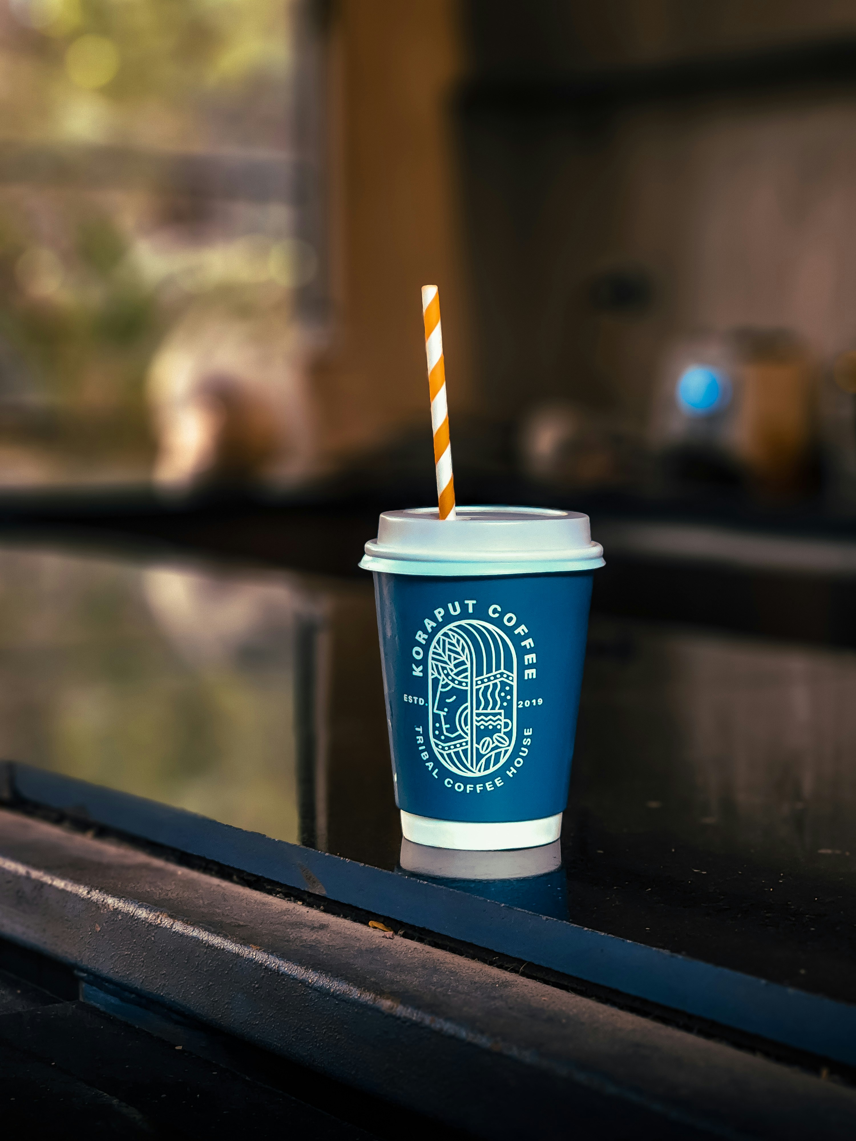 A blue cup with a straw in it sitting on a counter