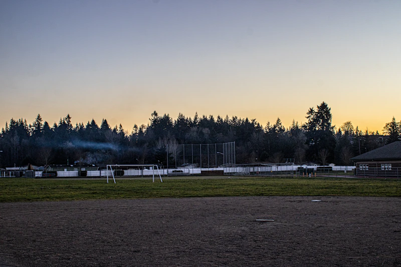 Baseball field with trees in the background at sunset