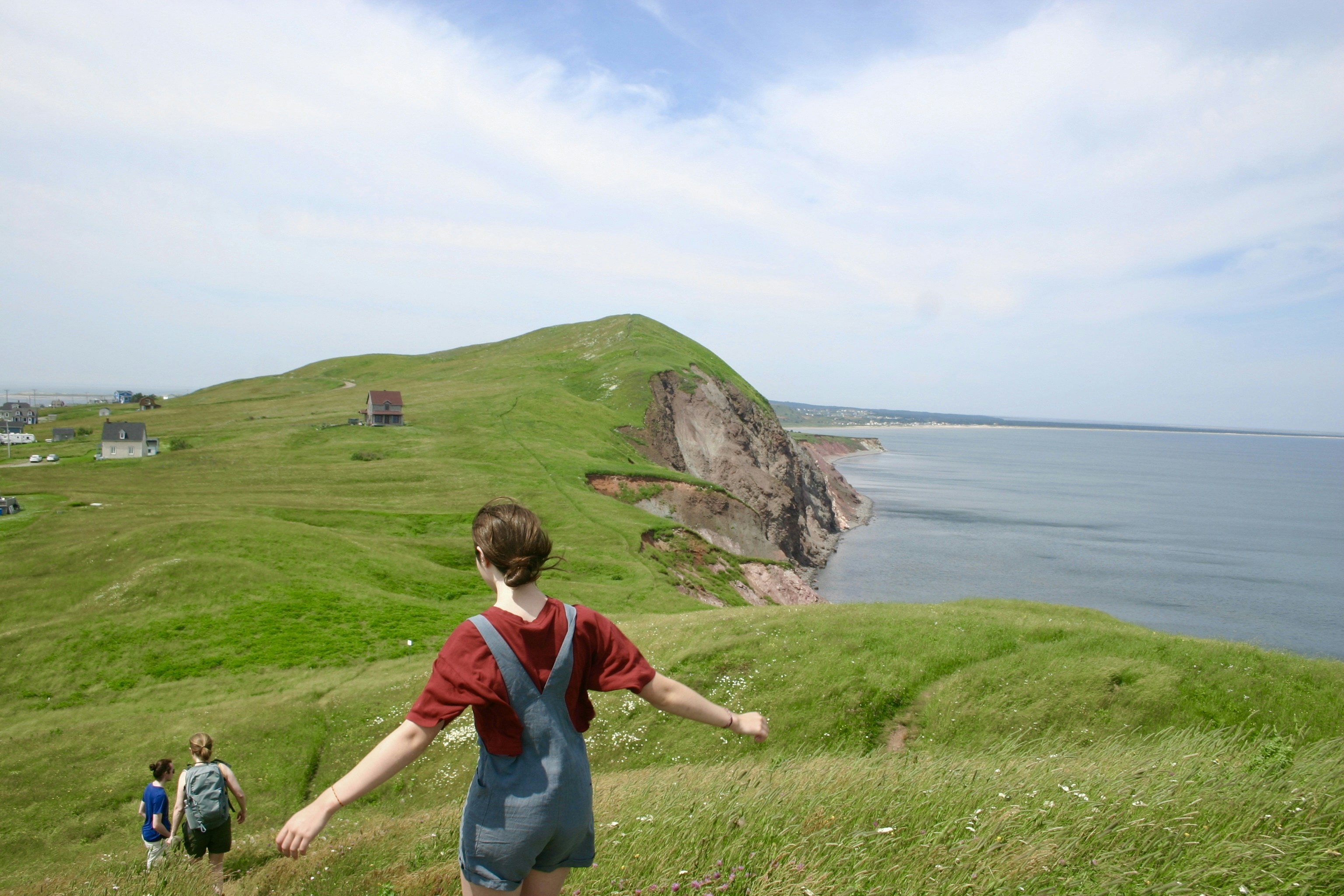 A man walking up a hill towards a body of water