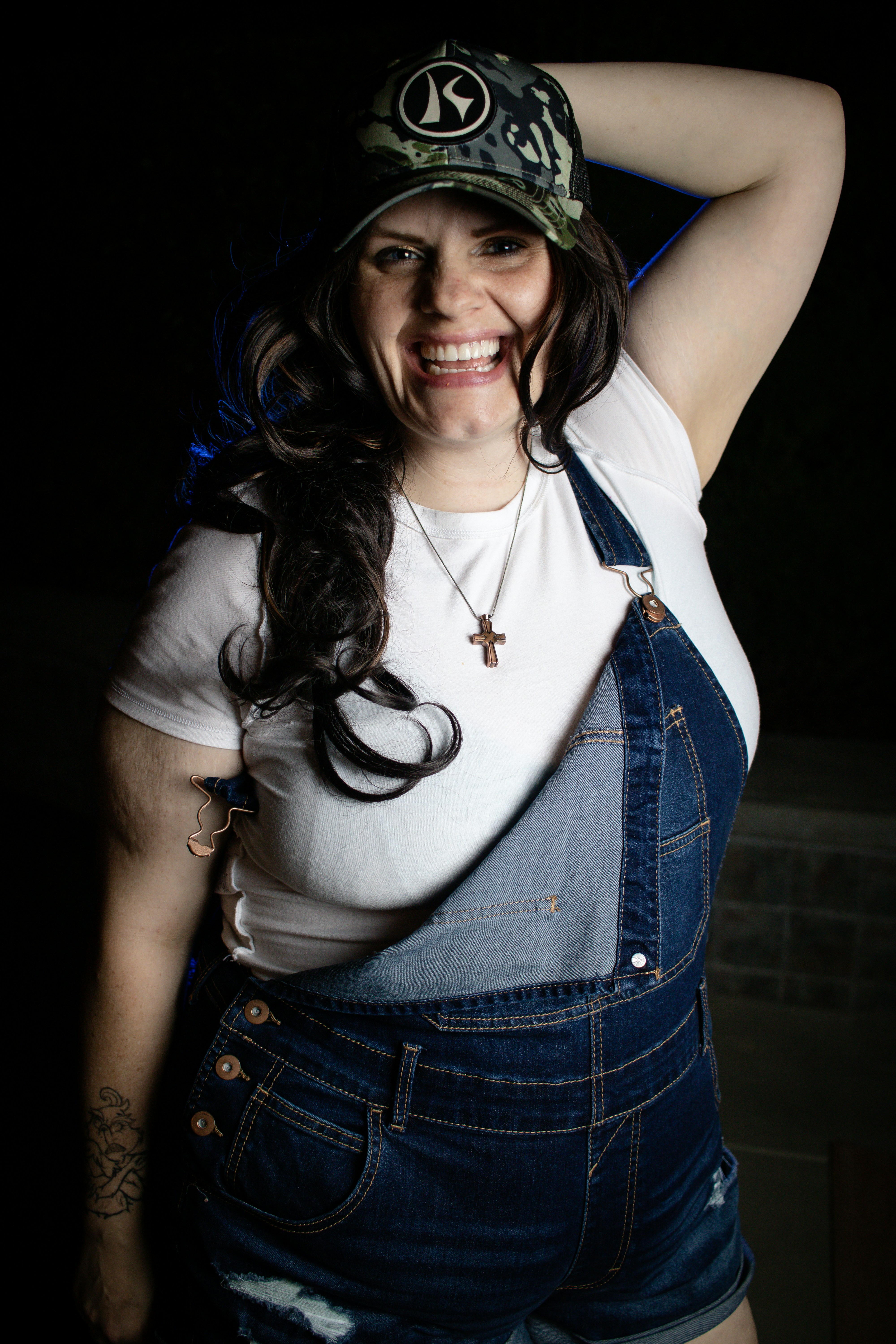 A woman wearing overalls and a hat