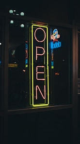 A neon open sign in the window of a restaurant