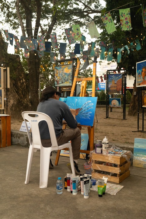 A man sitting on a chair in front of a painting