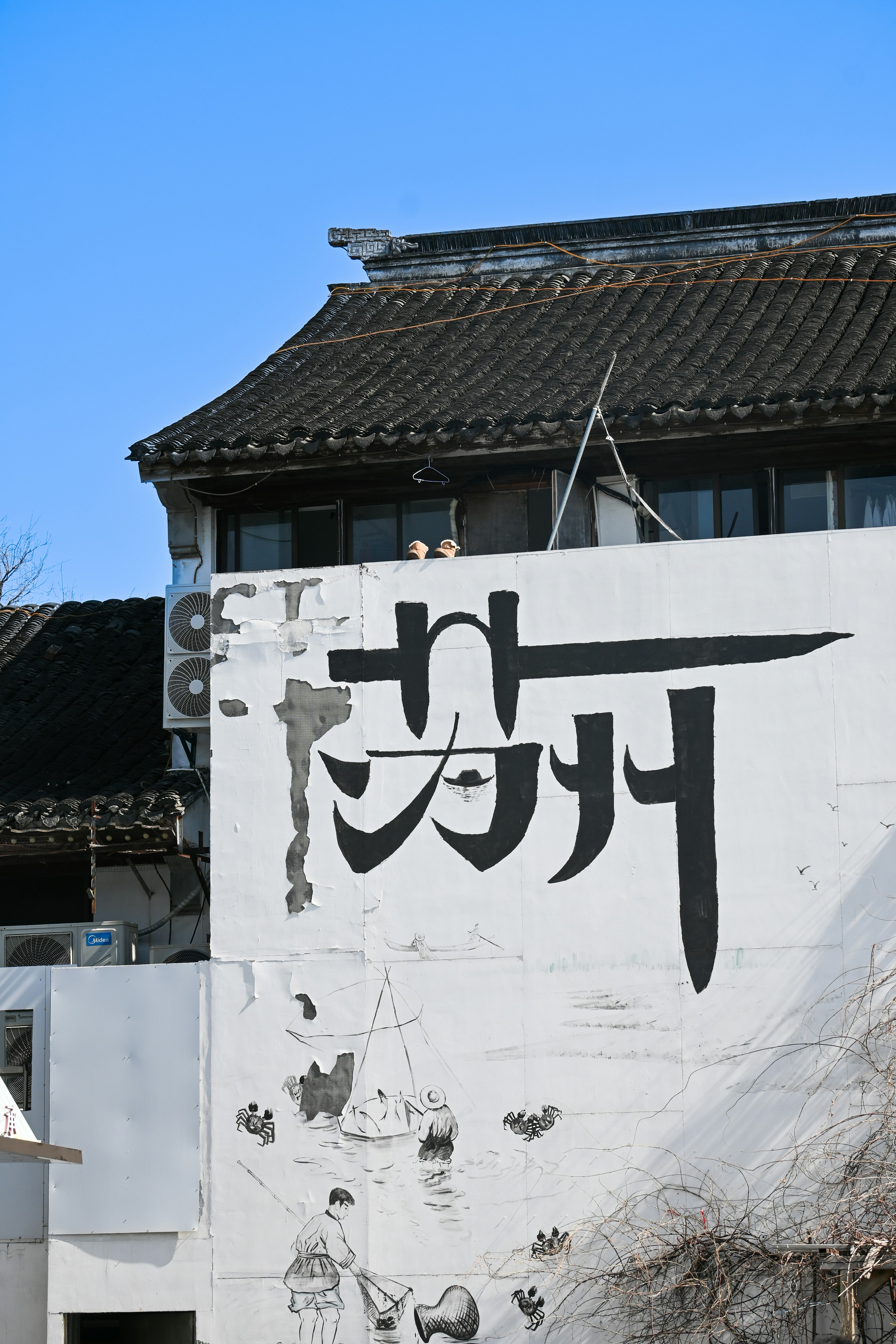 白い大きな建物で、その側面に看板が貼られています