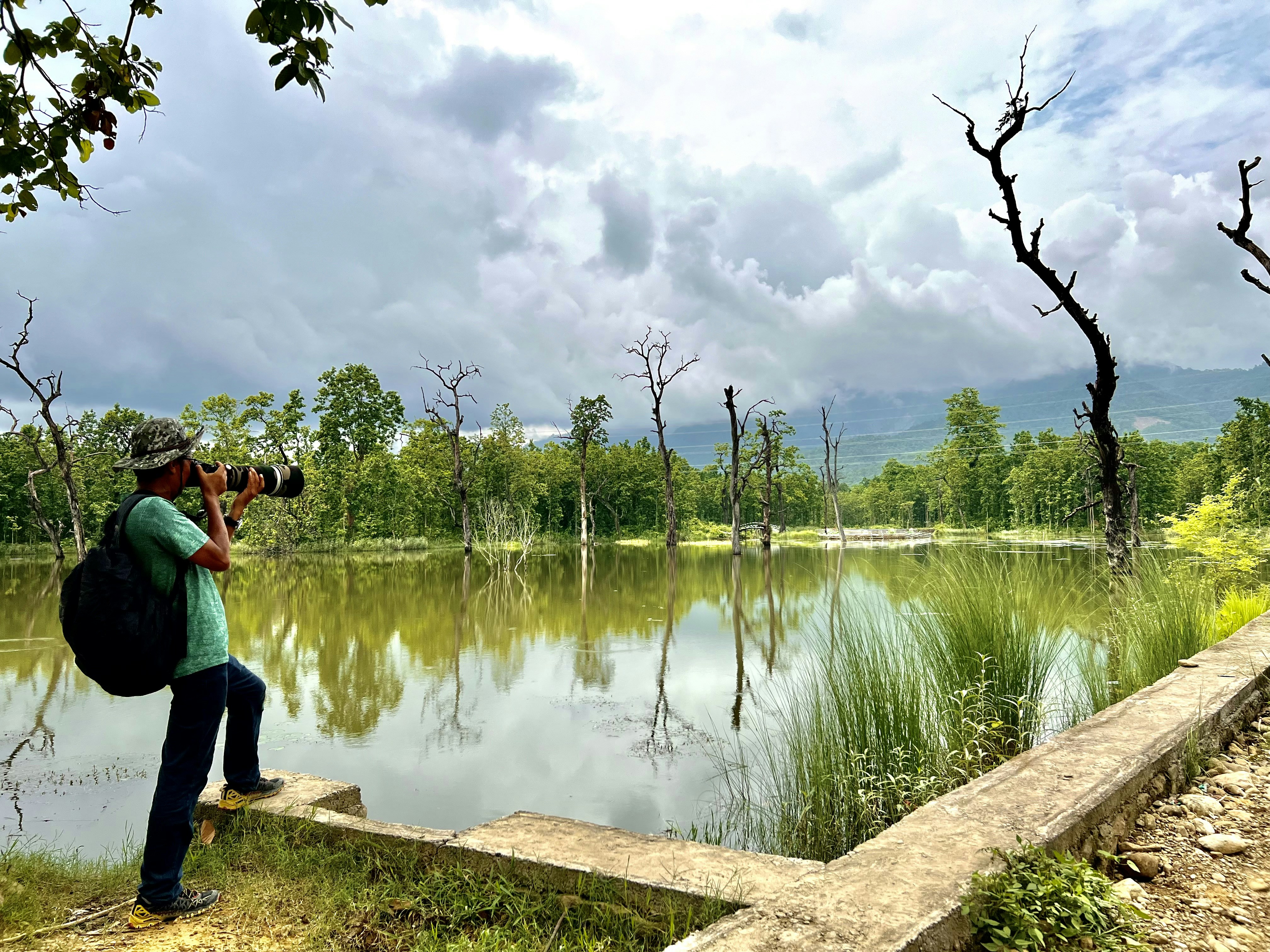 Un hombre con una mochila tomando una foto de un lago