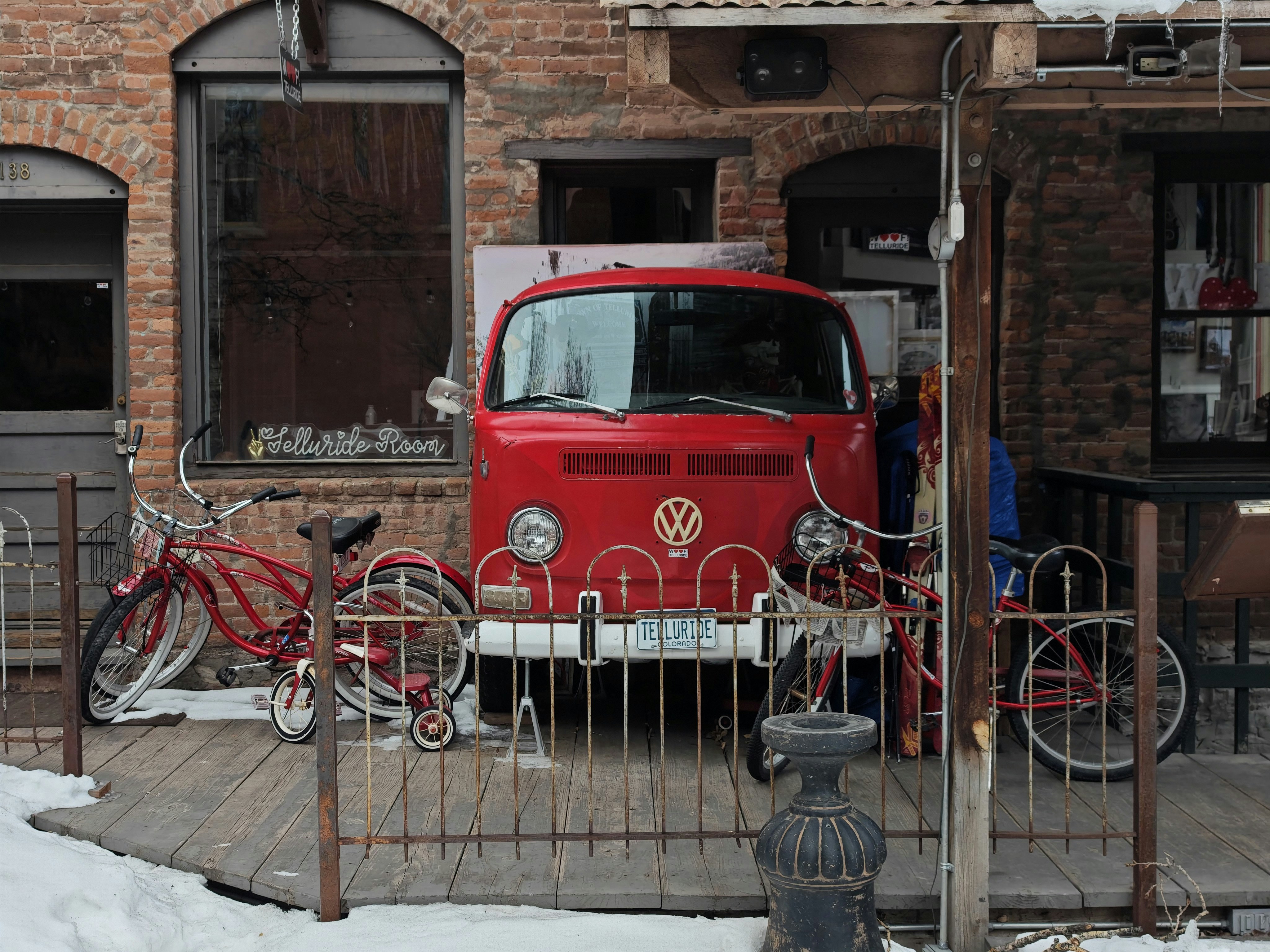 A red van parked in front of a brick building