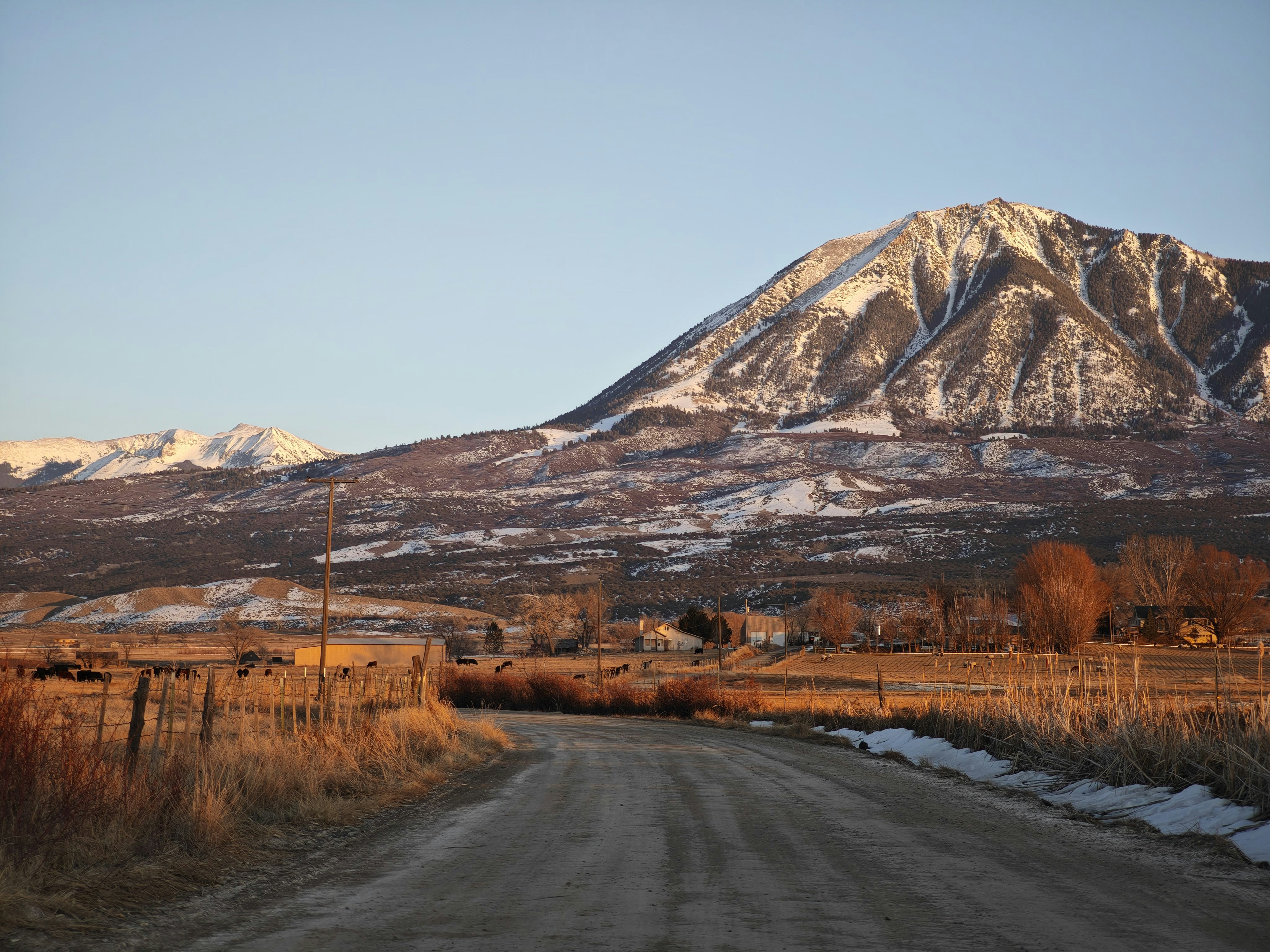 A dirt road with a mountain in the background