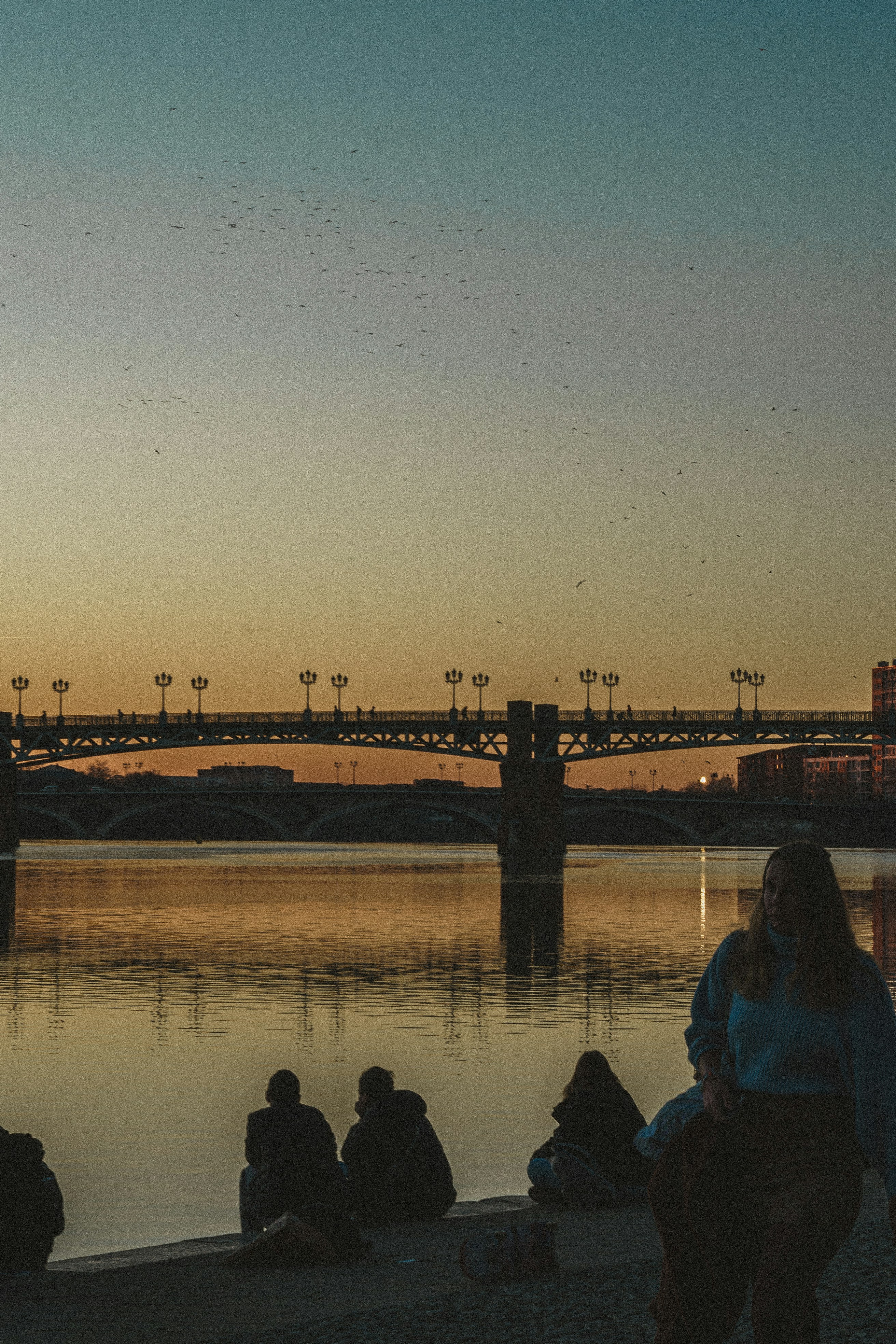 Un groupe de personnes assises au bord d’un plan d’eau