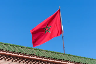 A red flag flying on top of a building