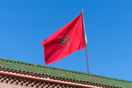 A red flag flying on top of a building