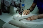 A woman using a sewing machine to sew fabric