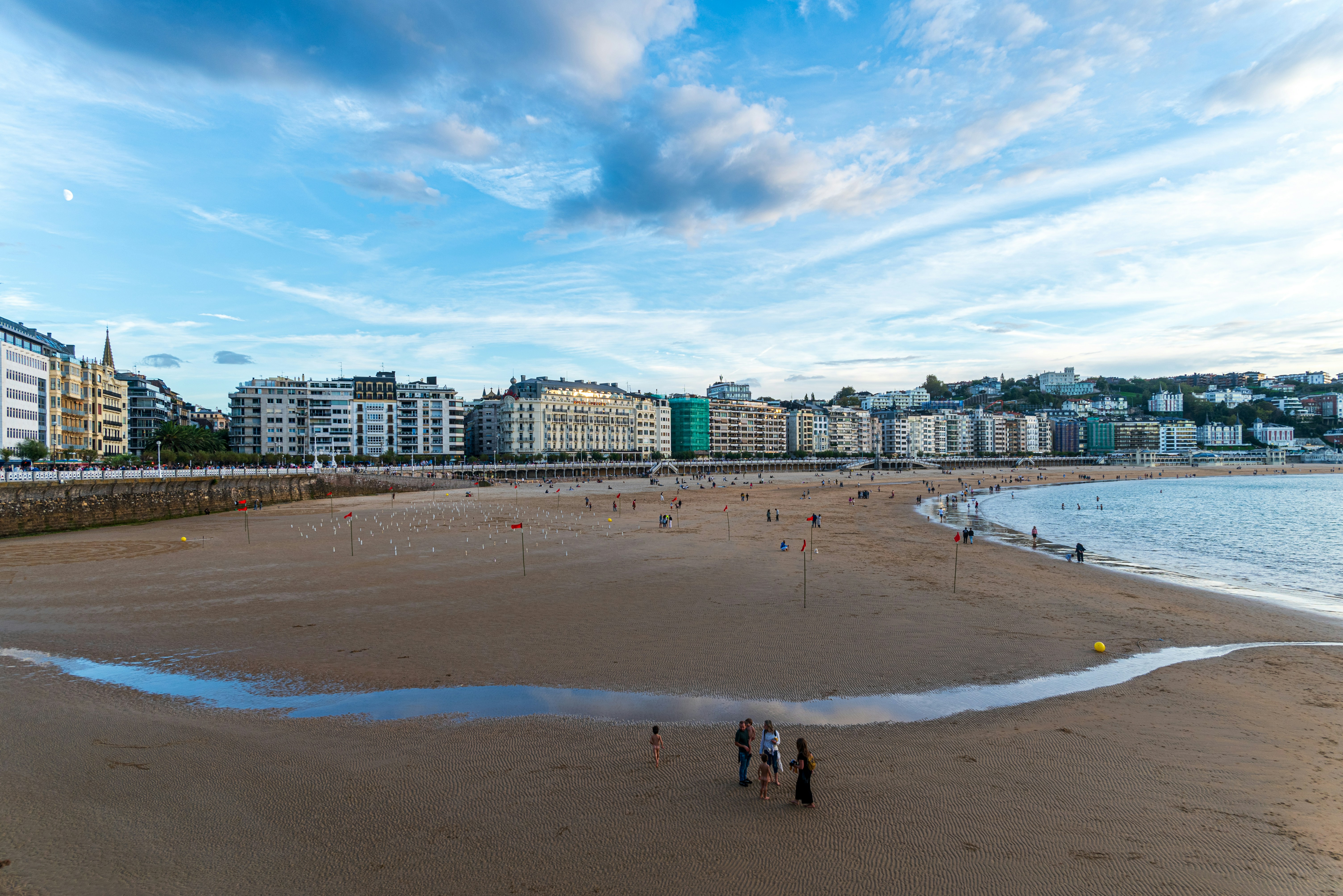 A group of people standing on top of a sandy beach