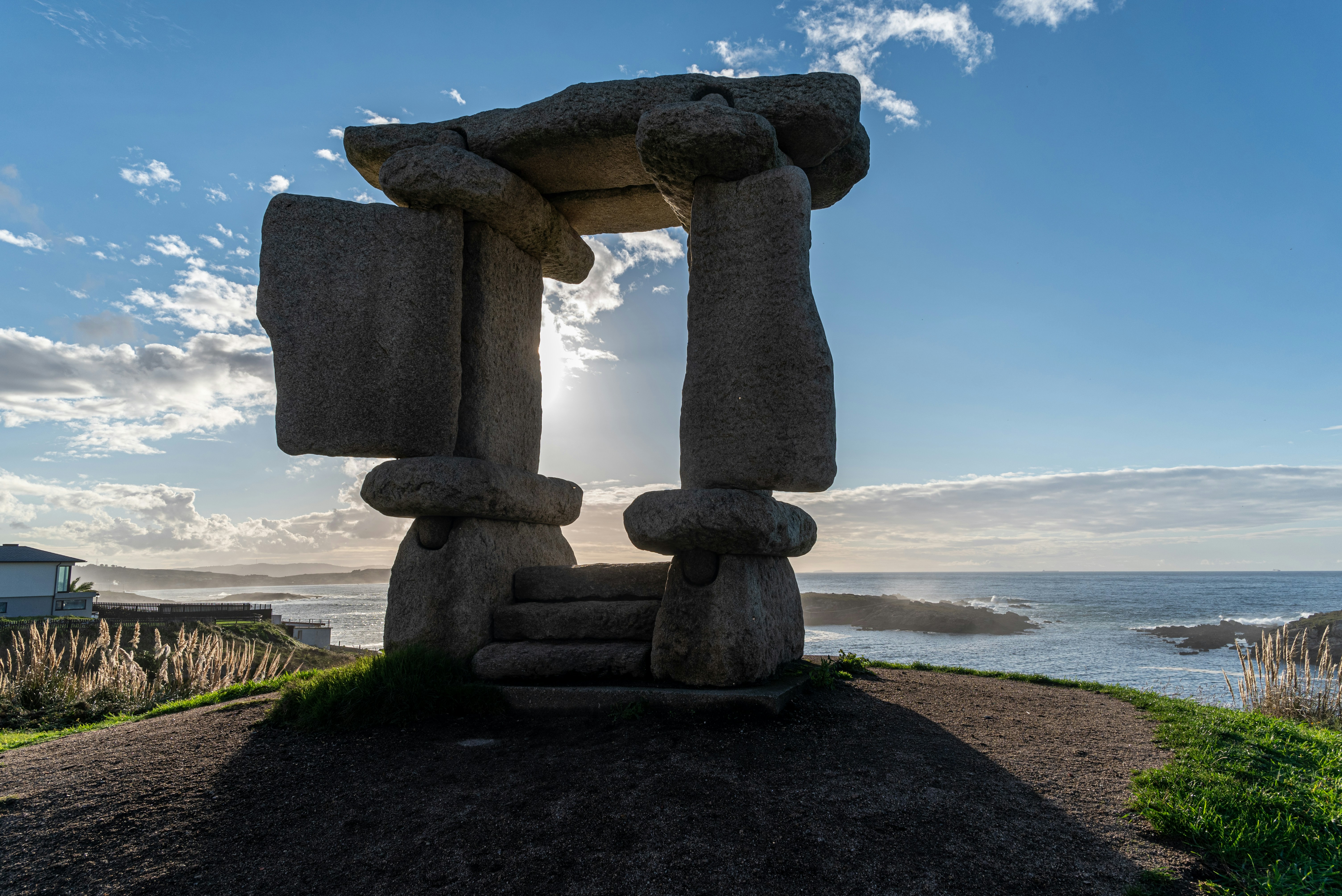 A stone sculpture sitting on top of a dirt field