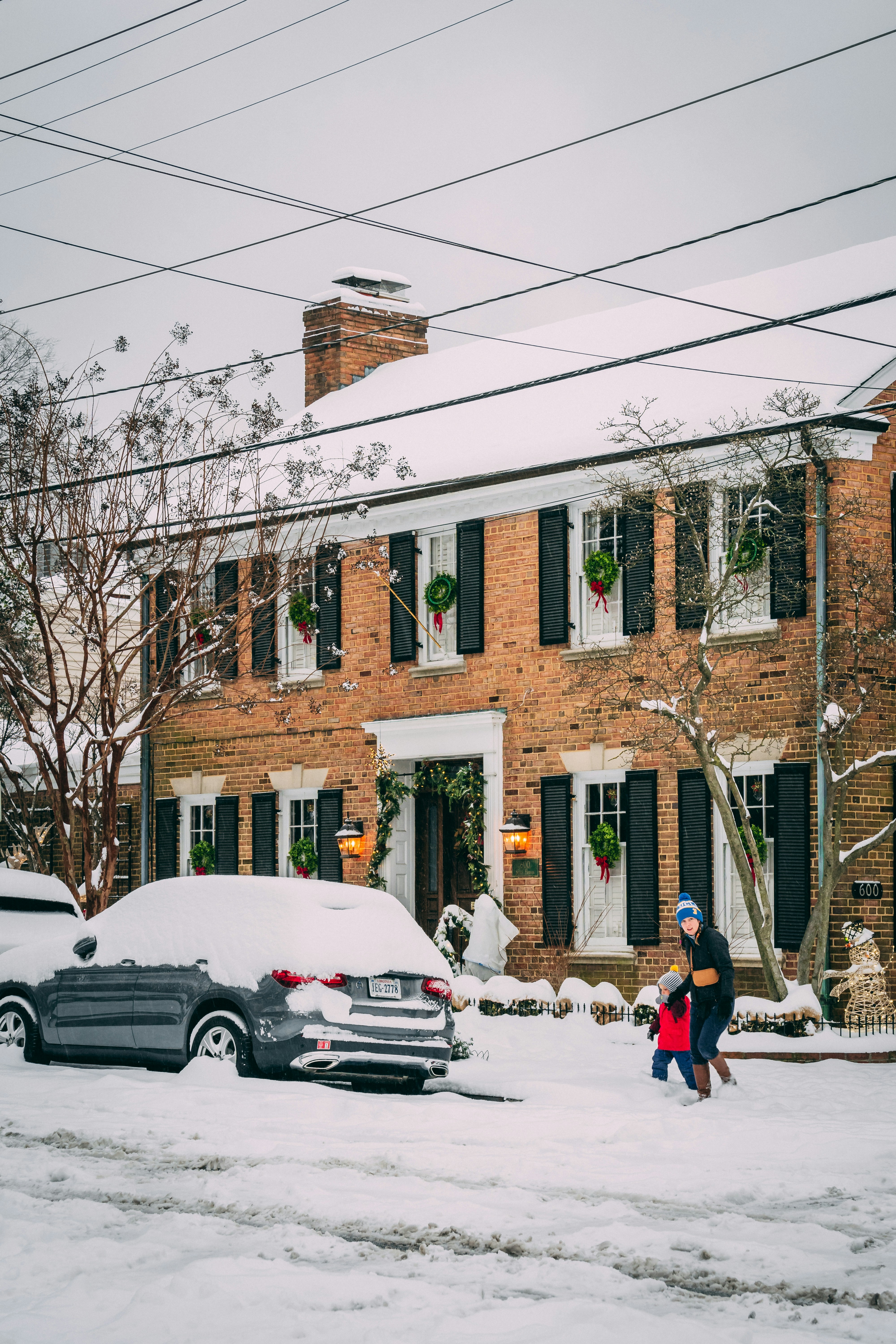 A man and a woman walking down a snow covered street