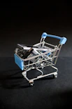 A miniature shopping cart with a cell phone in it