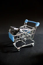 A miniature shopping cart with a cell phone in it