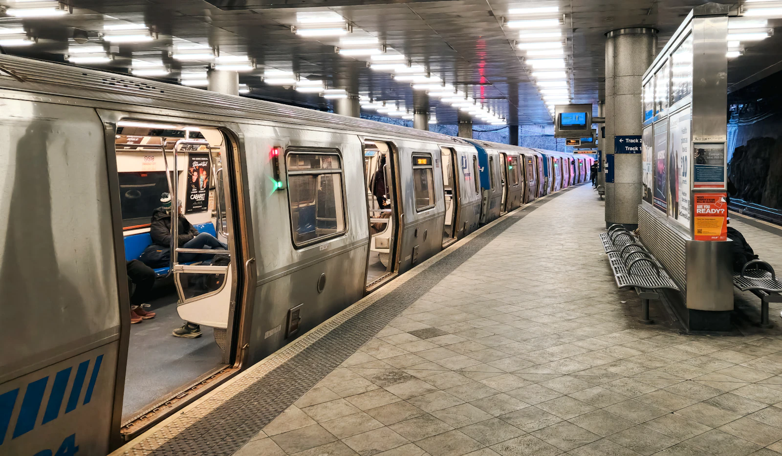 Travel photograph: A silver PATH train standing with its doors open at an underground station platform.